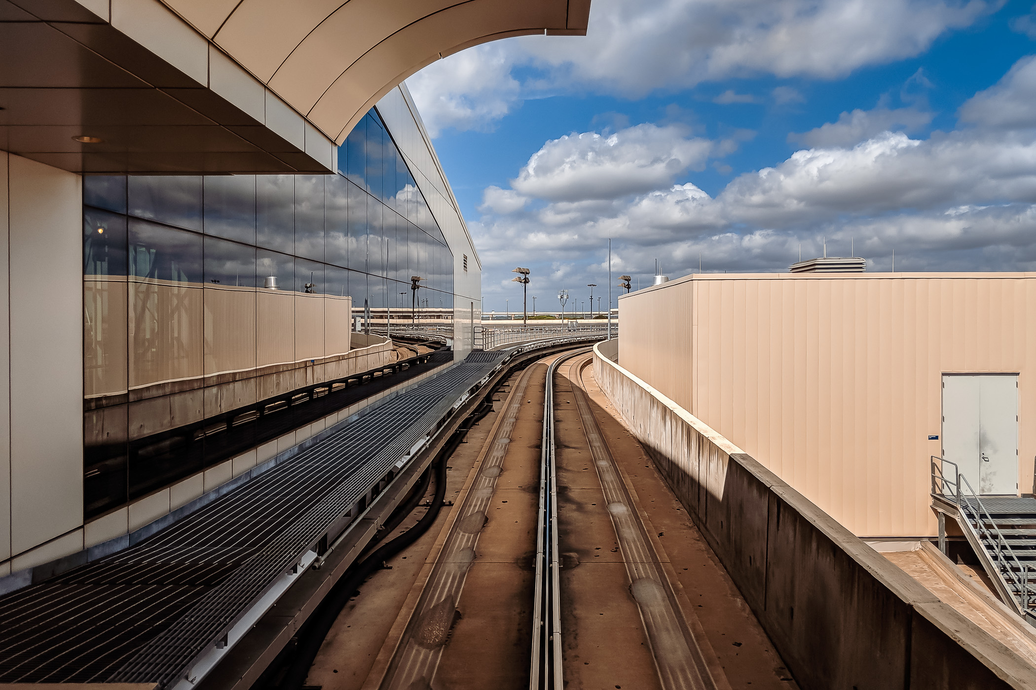 Tracks for the Skylink train lead away from a terminal at DFW International Airport, Texas.