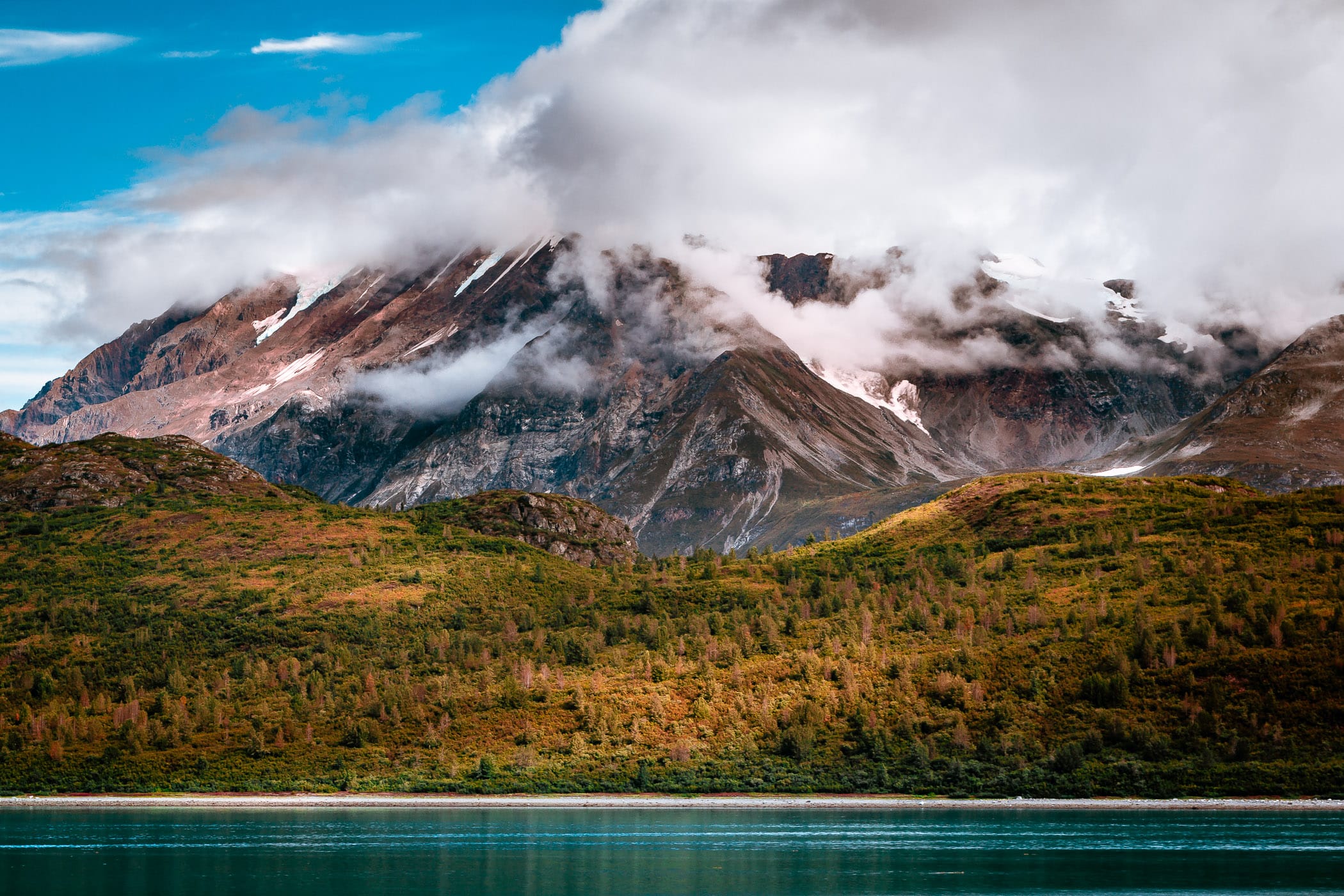 A mountain rises into the clouds at Glacier Bay National Park, Alaska.
