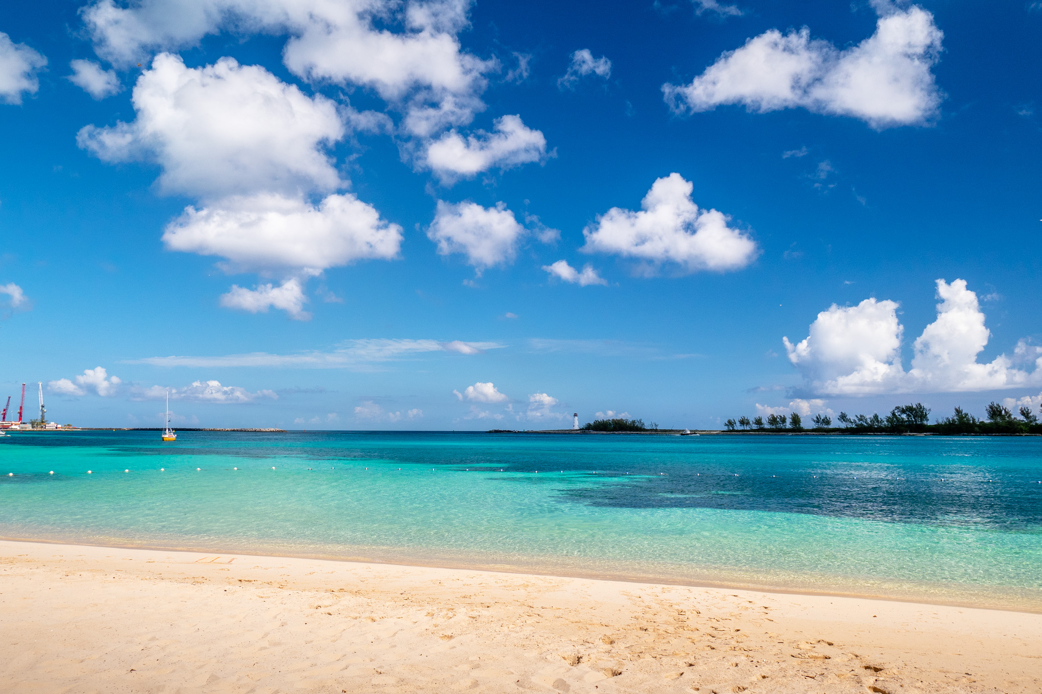 A lighthouse rises across the bay from a beach in Nassau, The Bahamas.