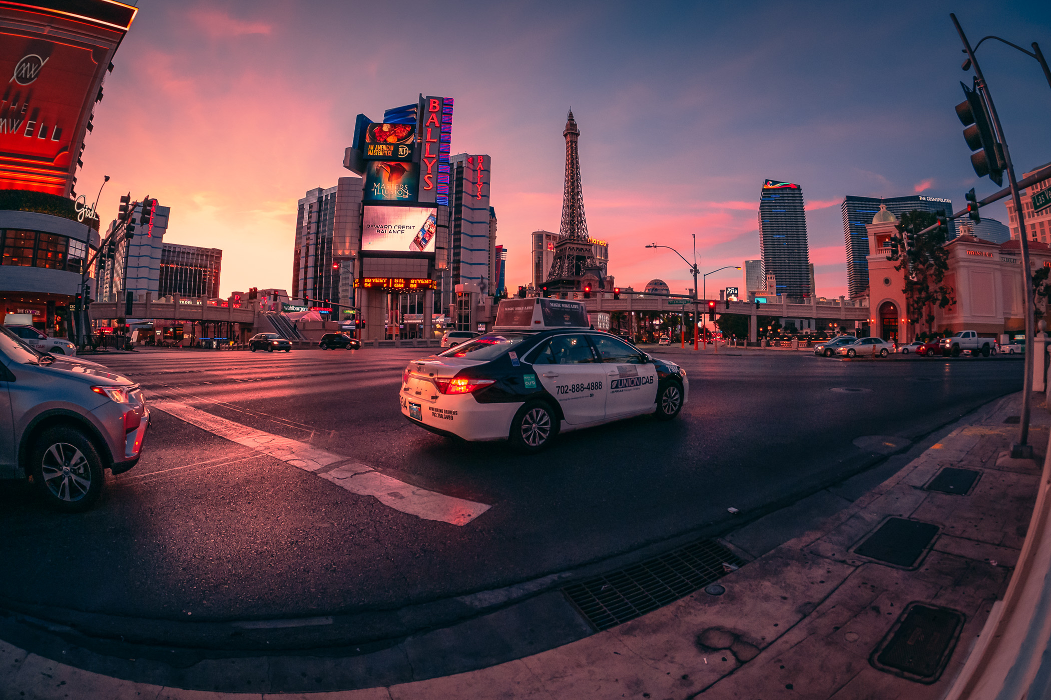 A taxi waits at a traffic light as the sun begins to rise on the Las Vegas Strip.