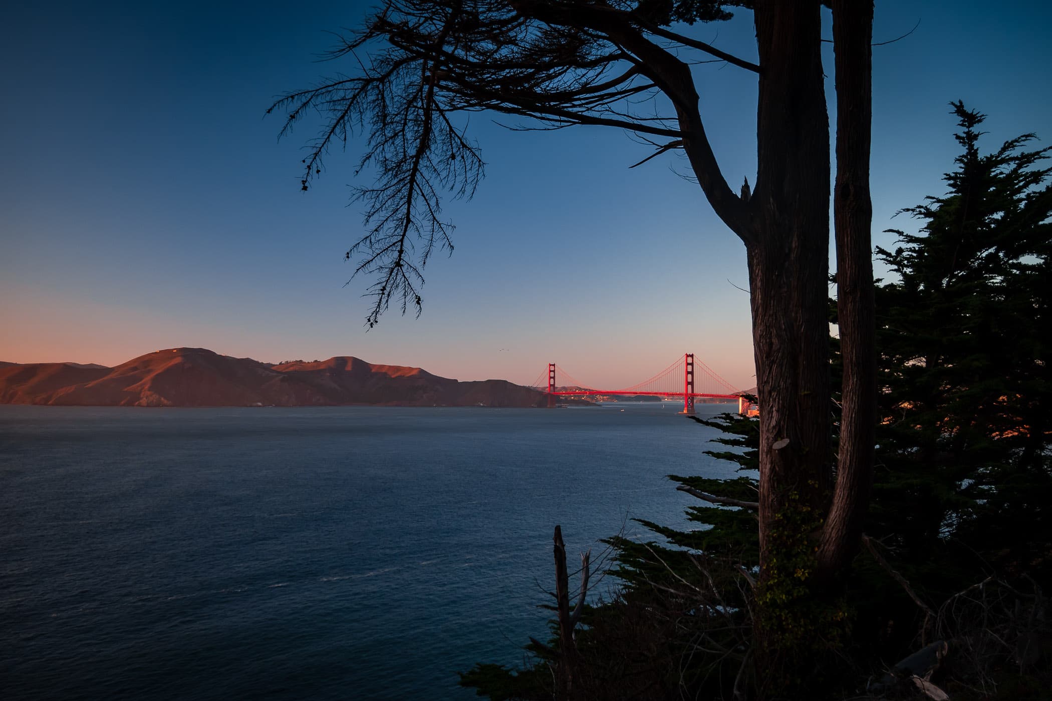 The last light of day illuminates San Francisco's Golden Gate Bridge.