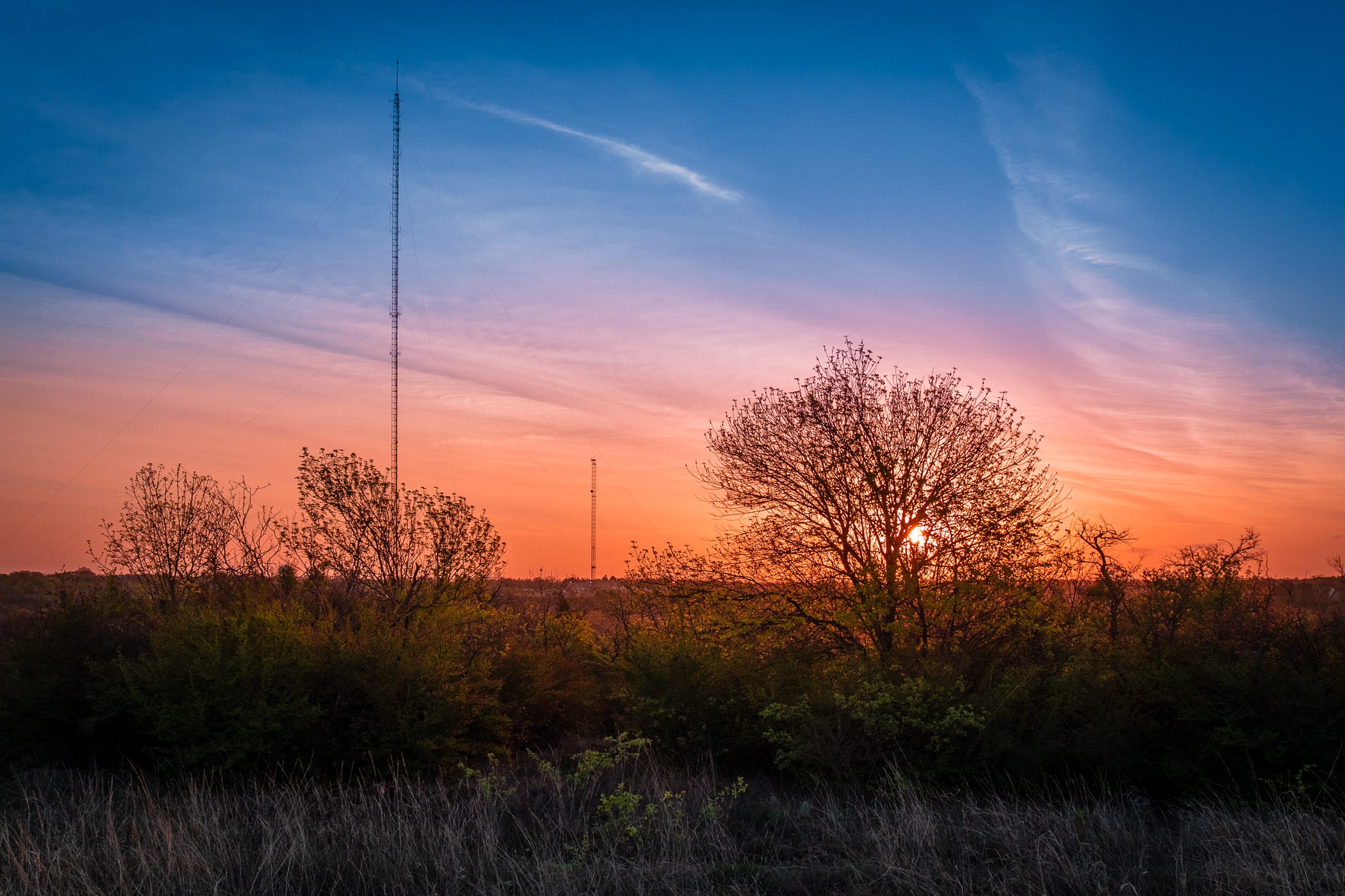 Broadcast towers rise into the sky as the sun rises over Fort Worth, Texas' Tandy Hills Natural Area.