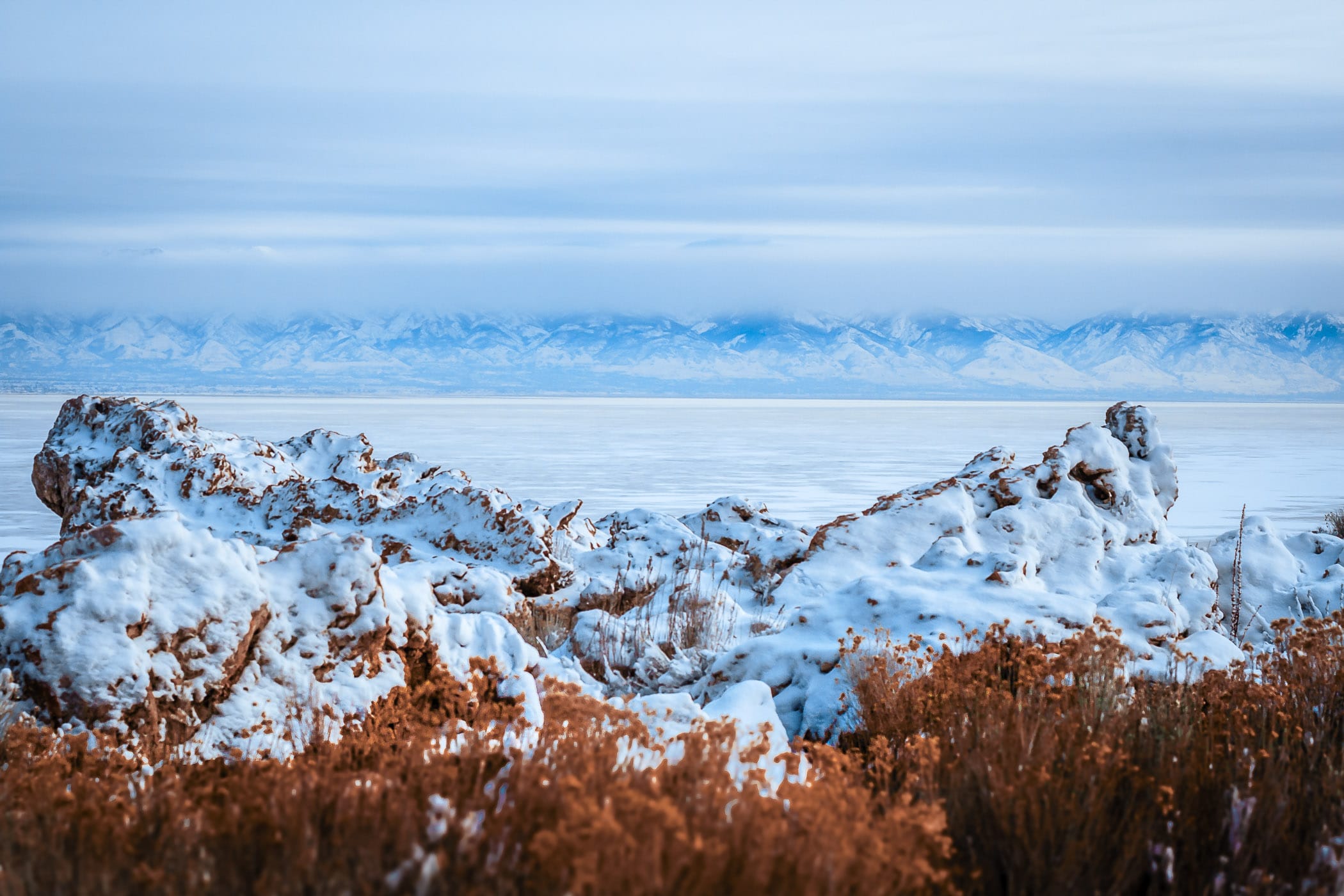 Distant winter mountains line the horizon as seen from the Great Salt Lake's Antelope Island, Utah.