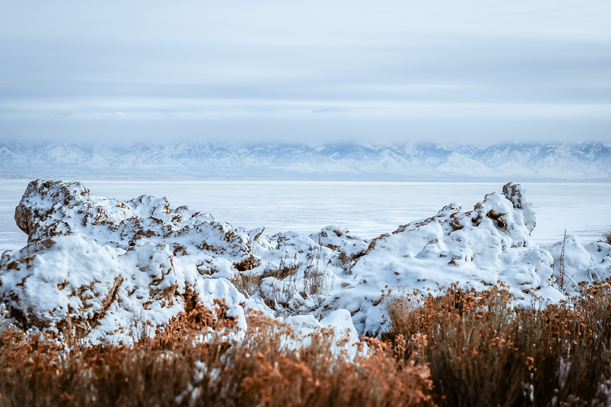 Distant winter mountains line the horizon as seen from the Great Salt Lake's Antelope Island, Utah.