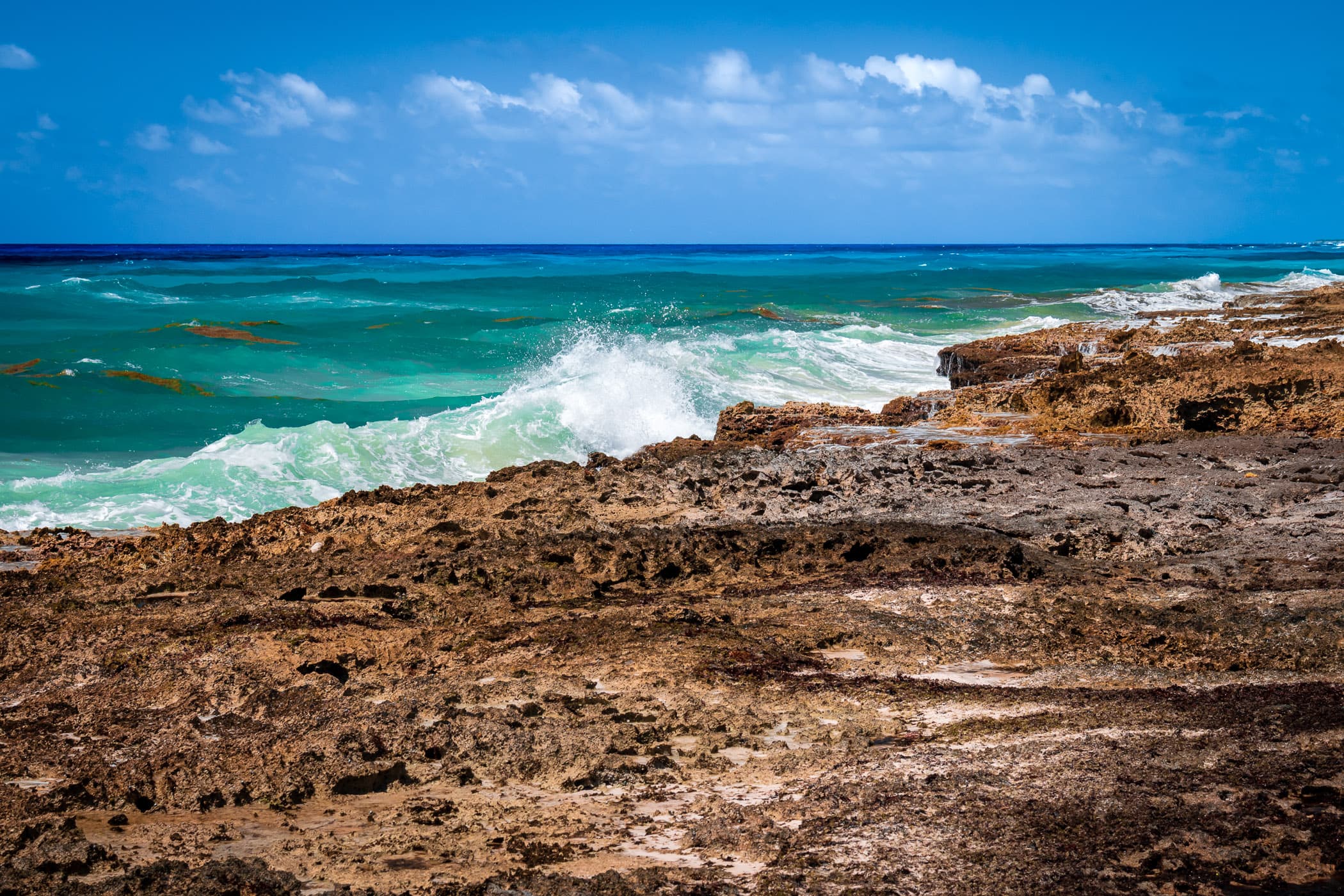 Waves crash onto the rough, rocky shore of the east side of Cozumel, Mexico.