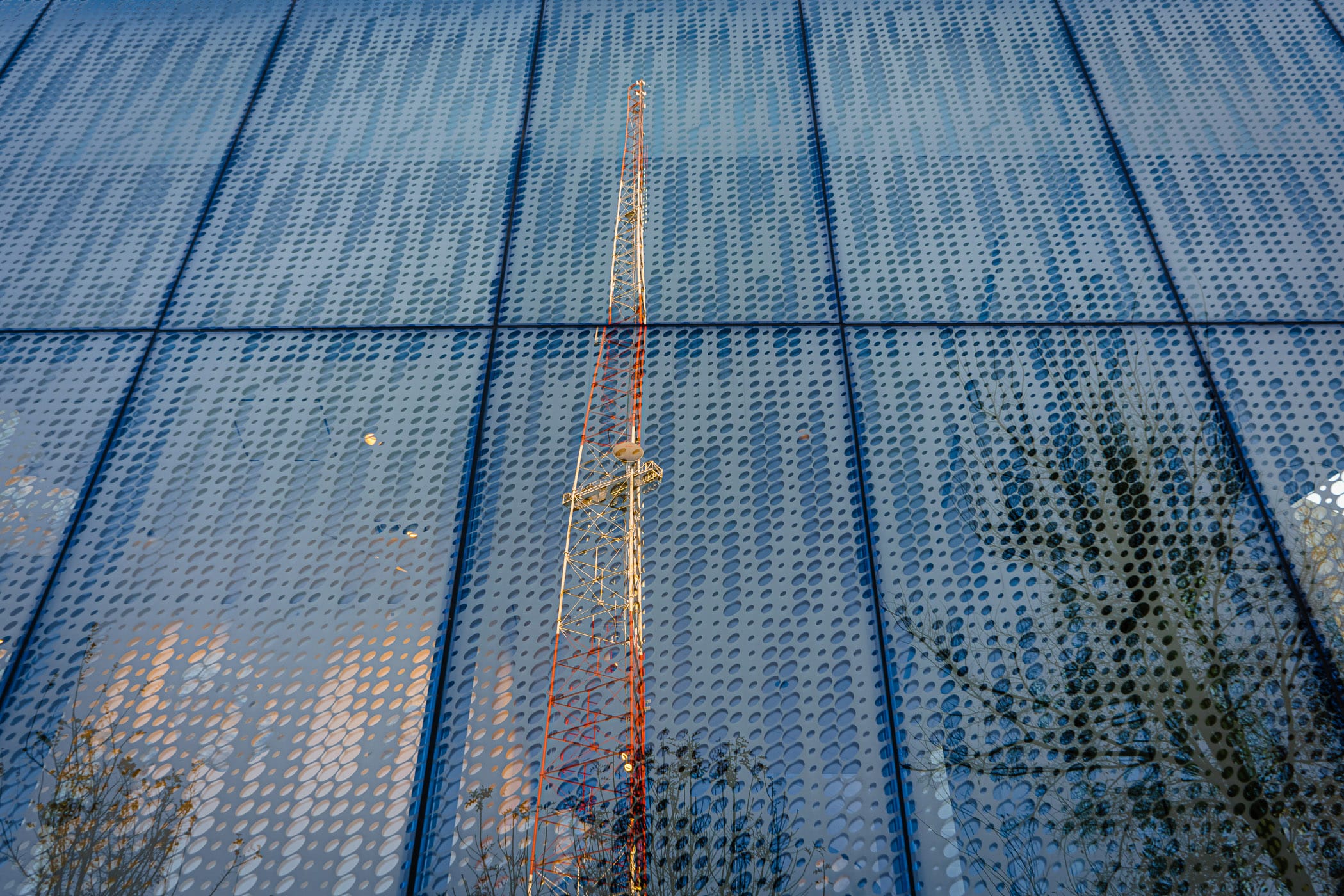 A nearby broadcast tower is reflected in the glass exterior of San Antonio's Tobin Center for the Performing Arts.