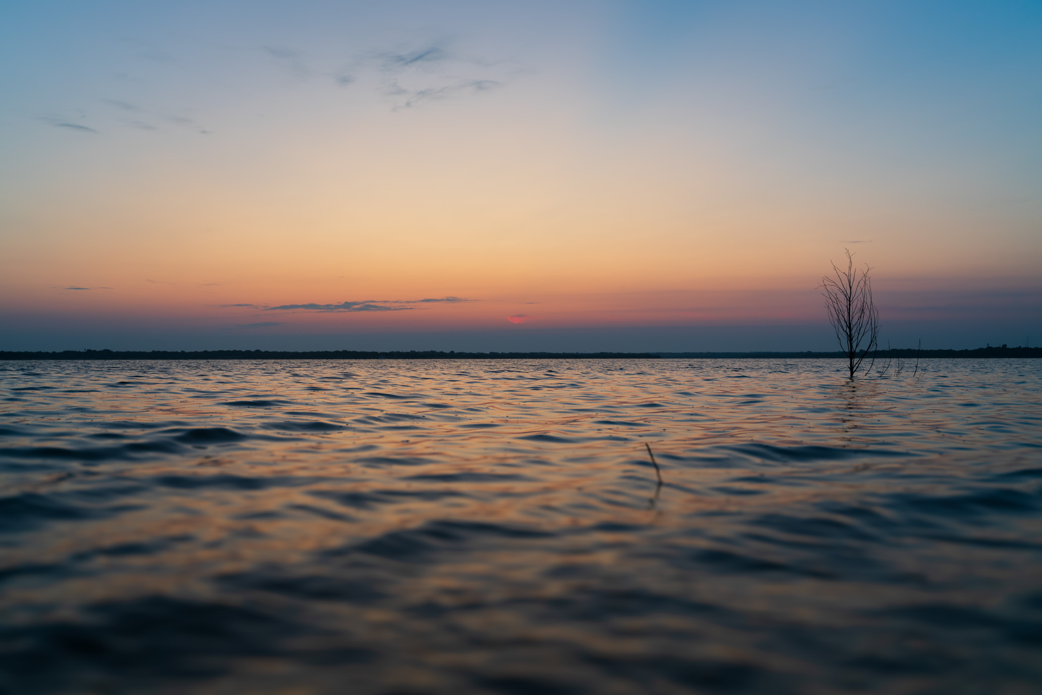 The calm, idyllic waters of North Texas' Lake Lavon as the sun begins to rise on a Summer morning.