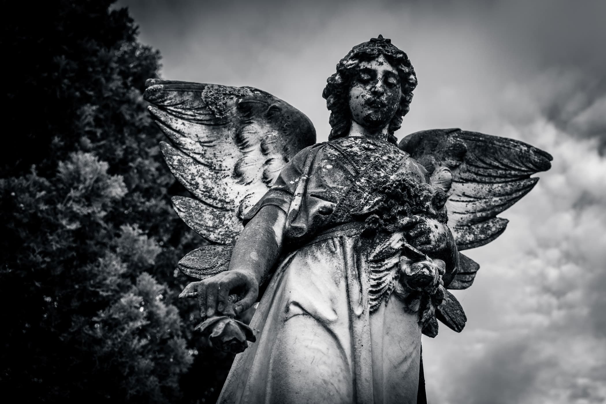 A statue of an angel atop a headstone at Pecan Grove Cemetery, McKinney, Texas.