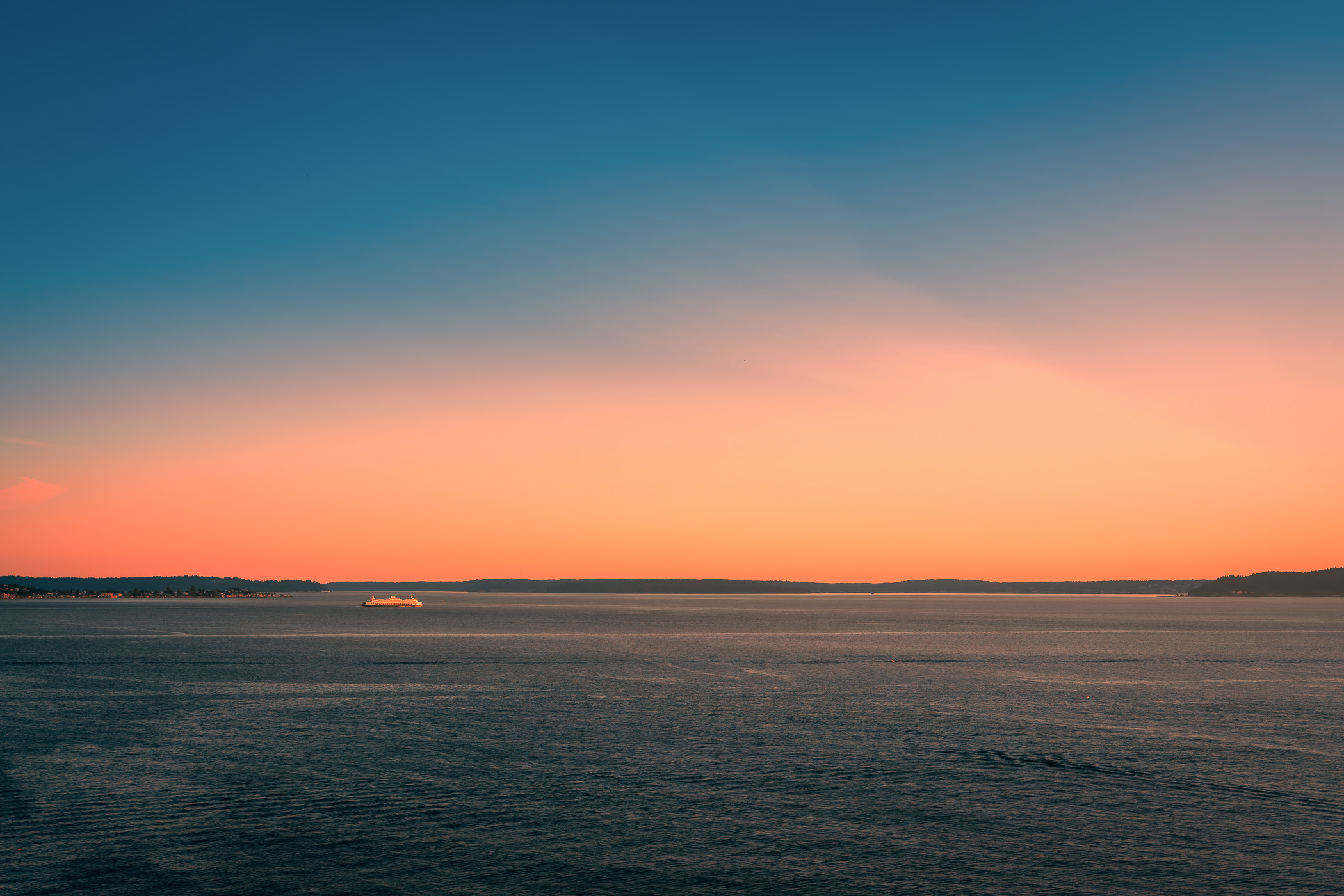 The sun sets on the Seattle-Bainbridge ferry as it crosses Puget Sound.