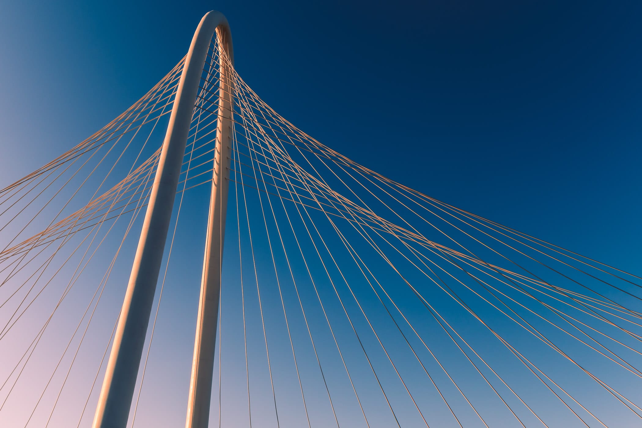 The graceful curve of Dallas' Margaret Hunt Hill Bridge arches through the morning sky.