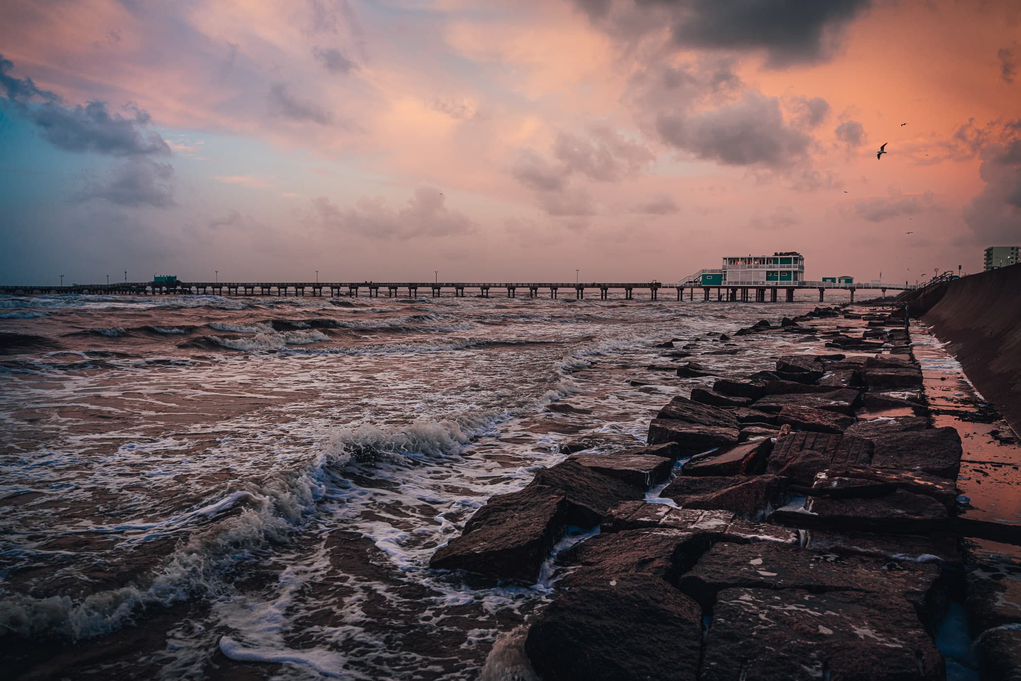 The Galveston Fishing Pier reaches into the morning surf of the Gulf of Mexico.