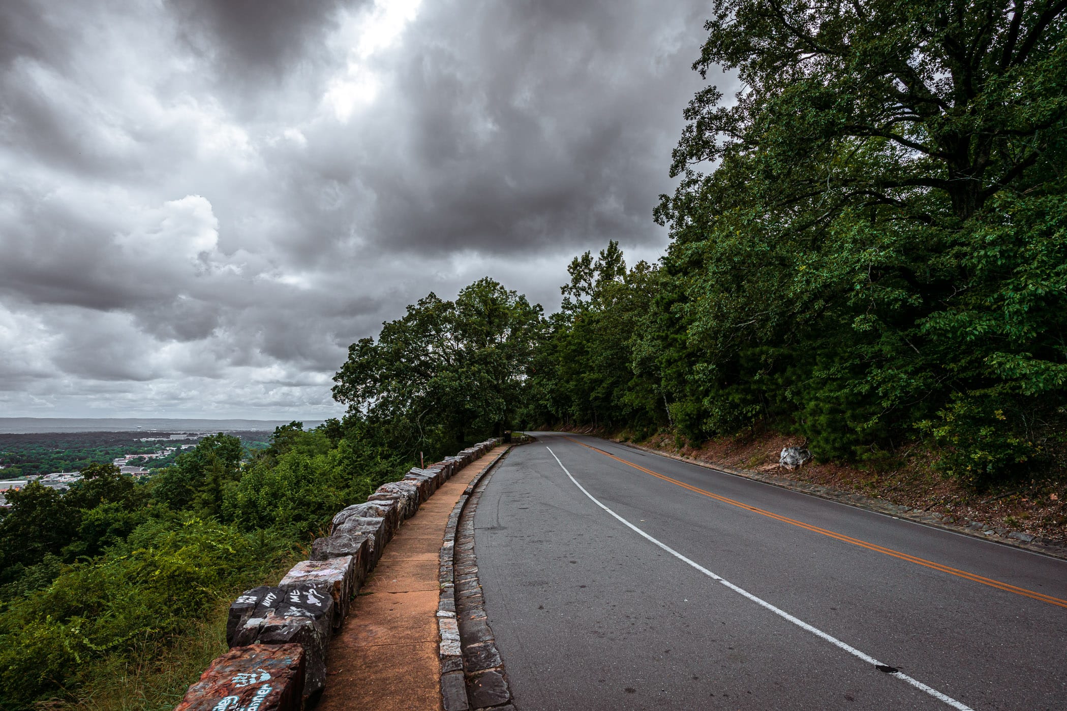 A road curves around a mountaintop overlooking Hot Springs, Arkansas.