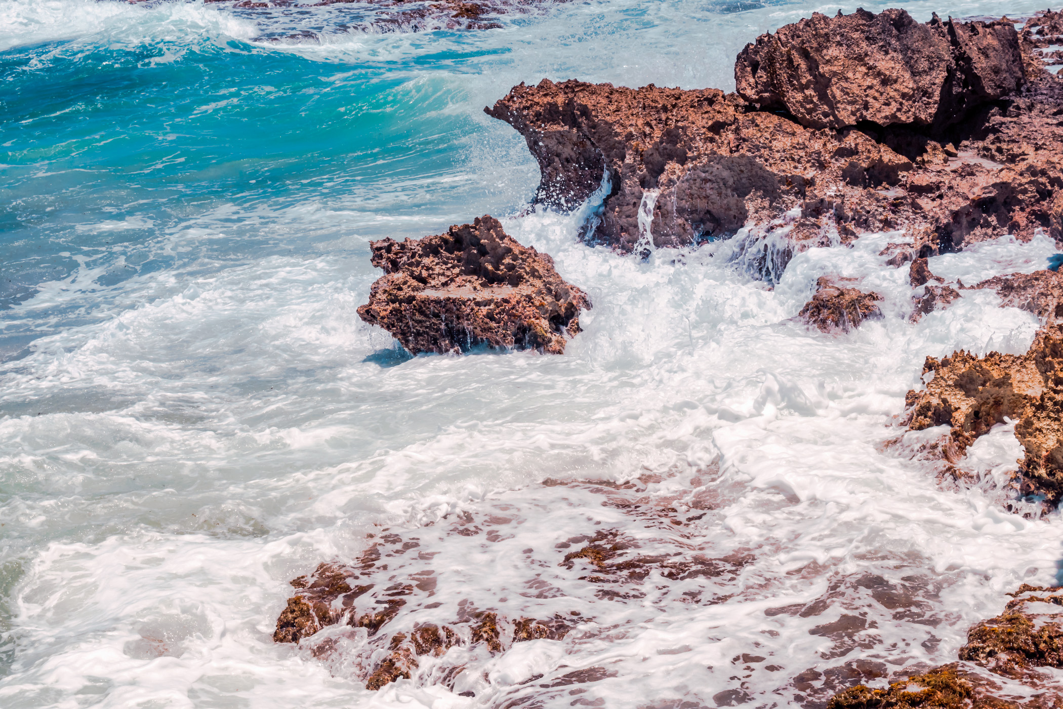 Waves crash onto jagged rocks at Cozumel, Mexico's El Mirador.