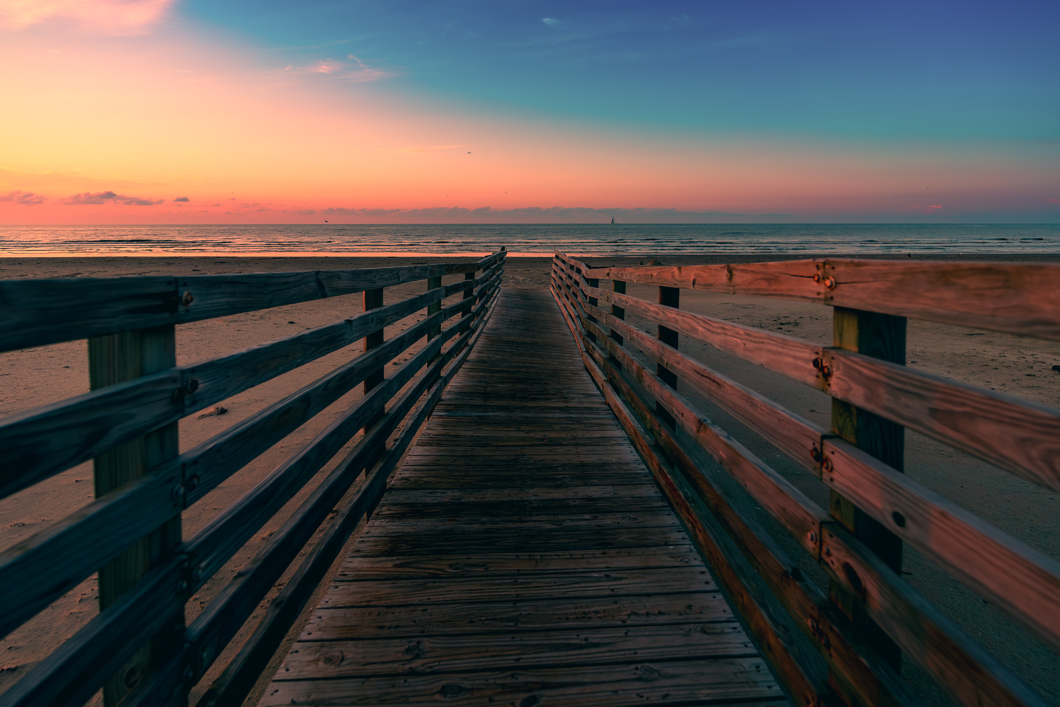 A wooden walkway leads to the Gulf of Mexico beach on Galveston Island, Texas.