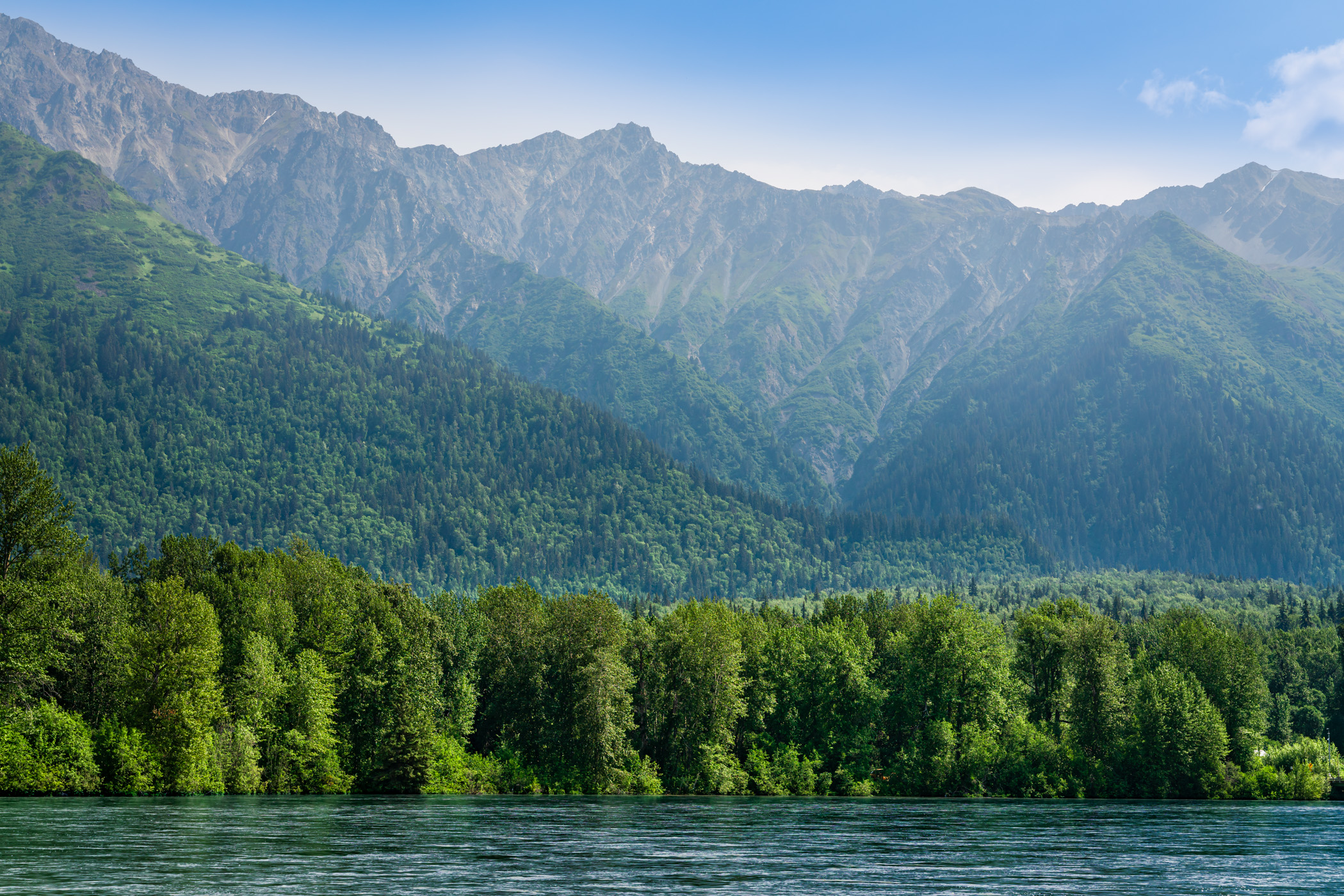 Haze obscures the mountainous landscape along the Chilkat River near Haines, Alaska.