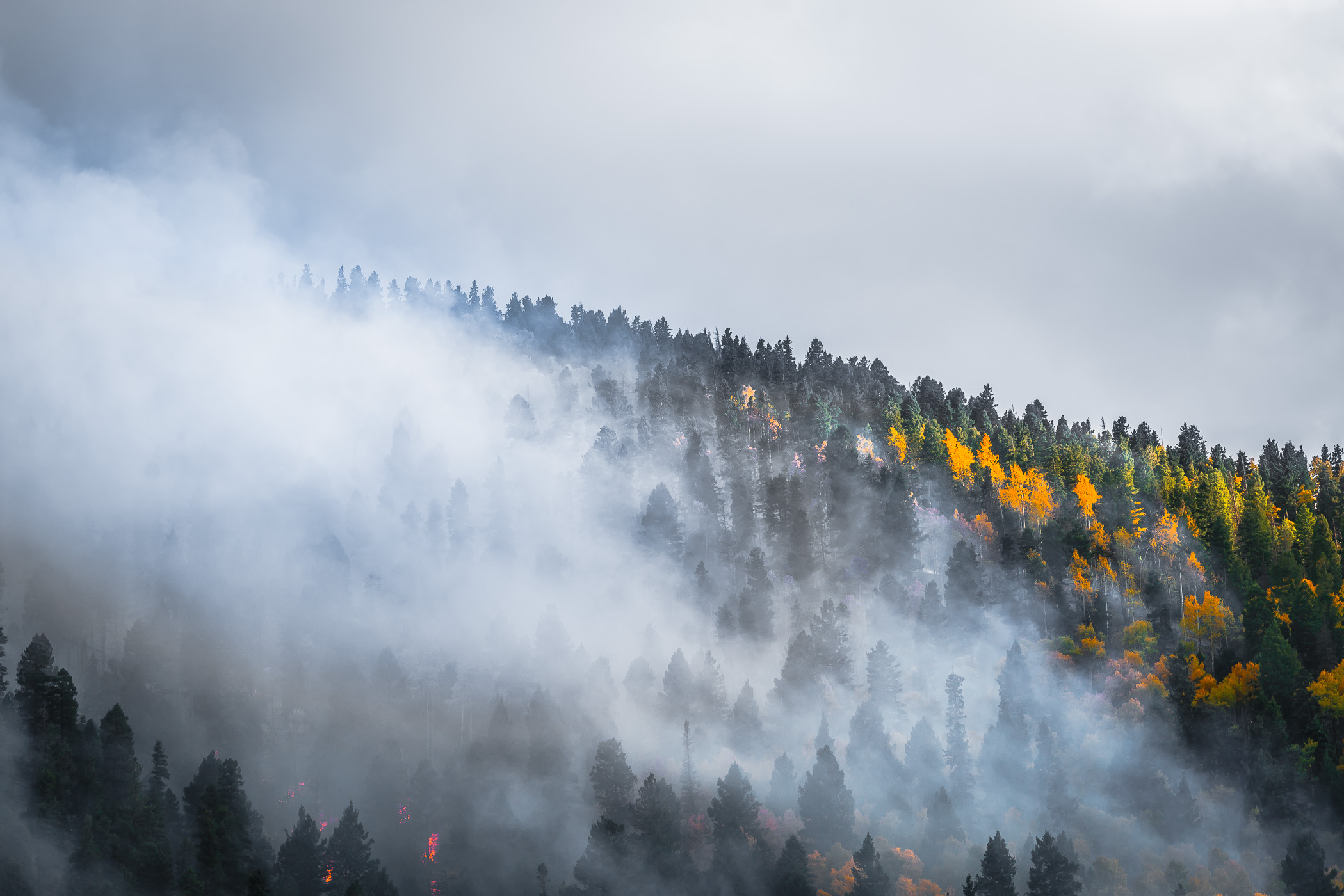 A forest fire smolders in the mountains near Taos, New Mexico.