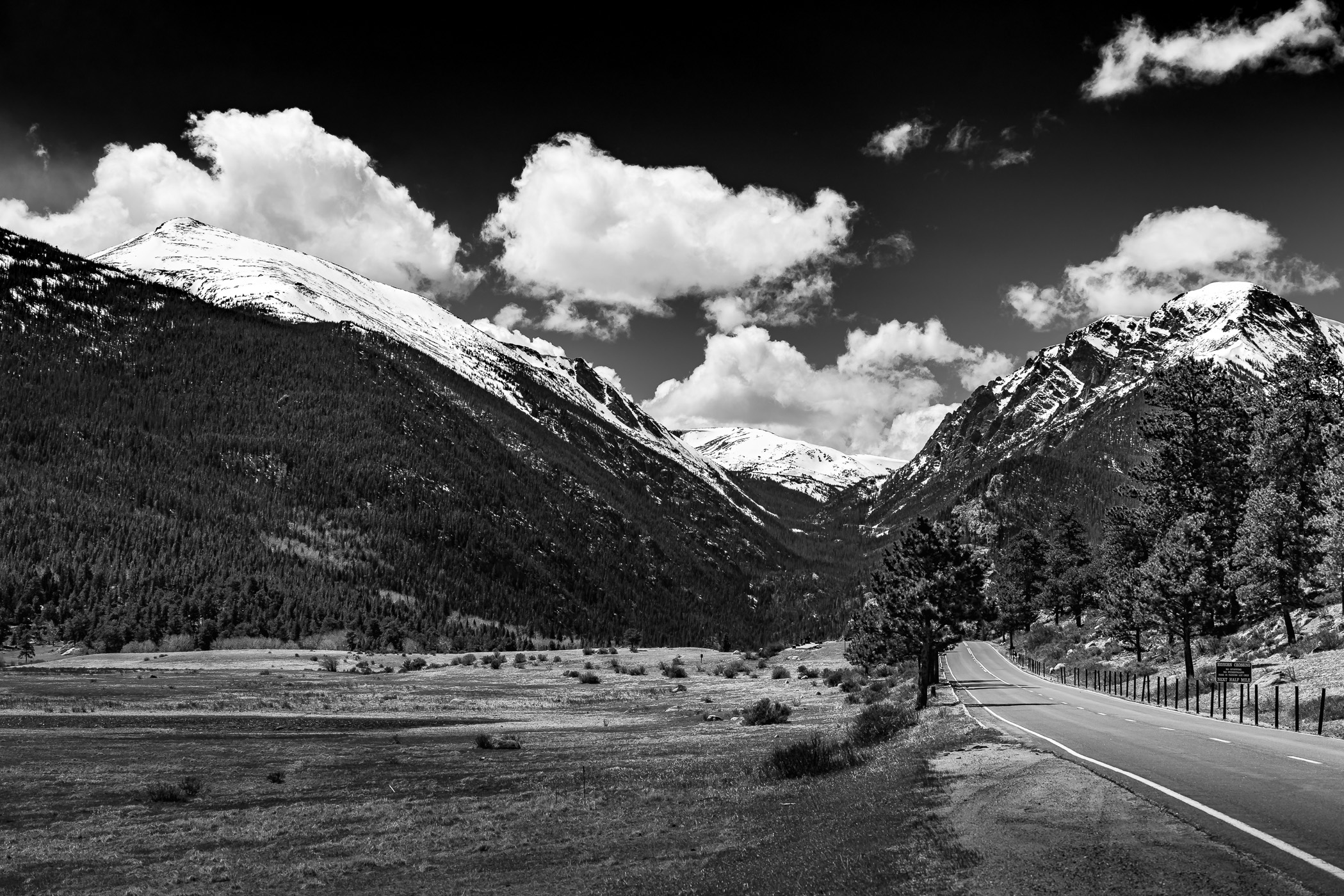 A road leads to snowcapped mountains at Colorado's Rocky Mountain National Park.