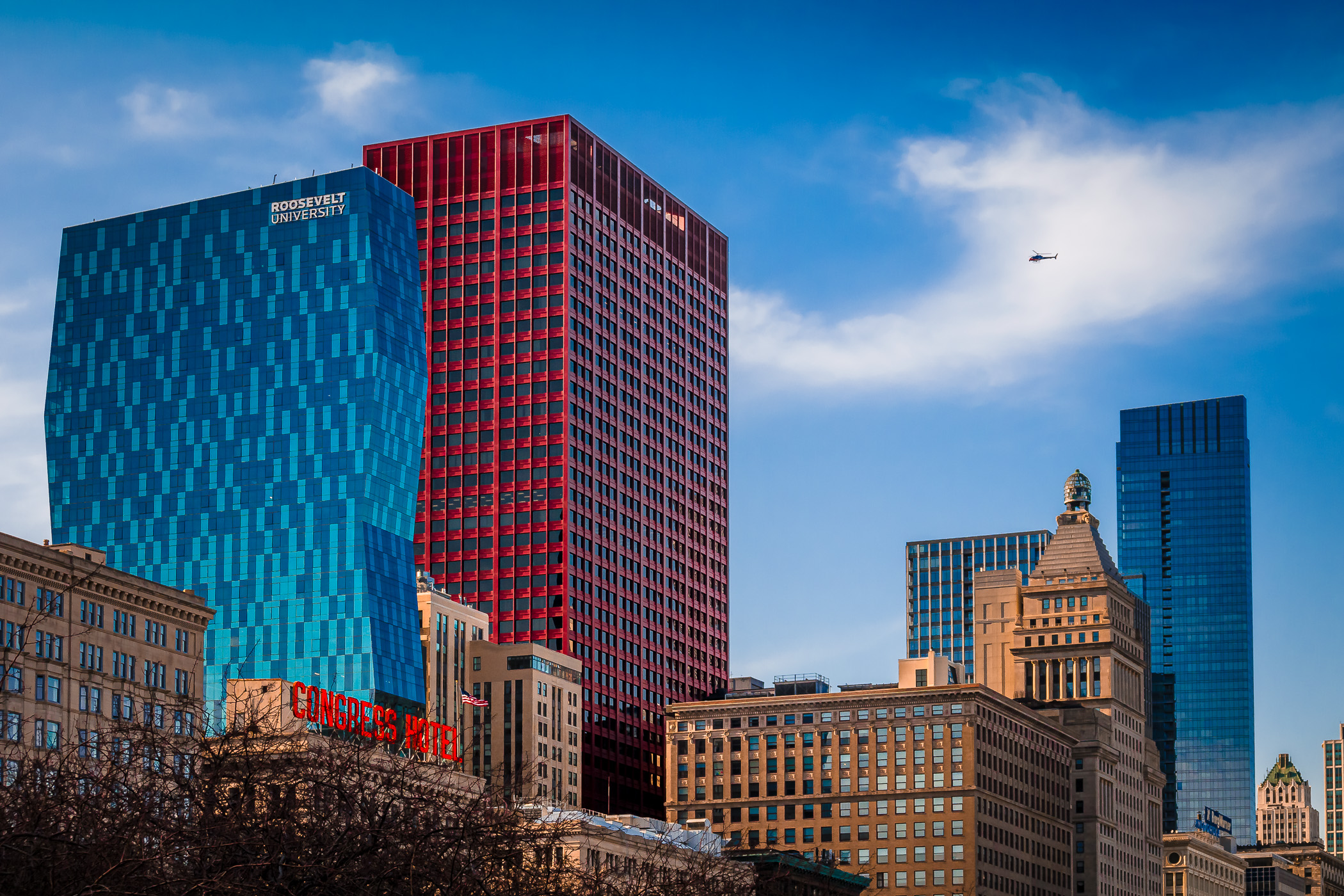 A helicopter flies over Downtown Chicago as seen from Grant Park.