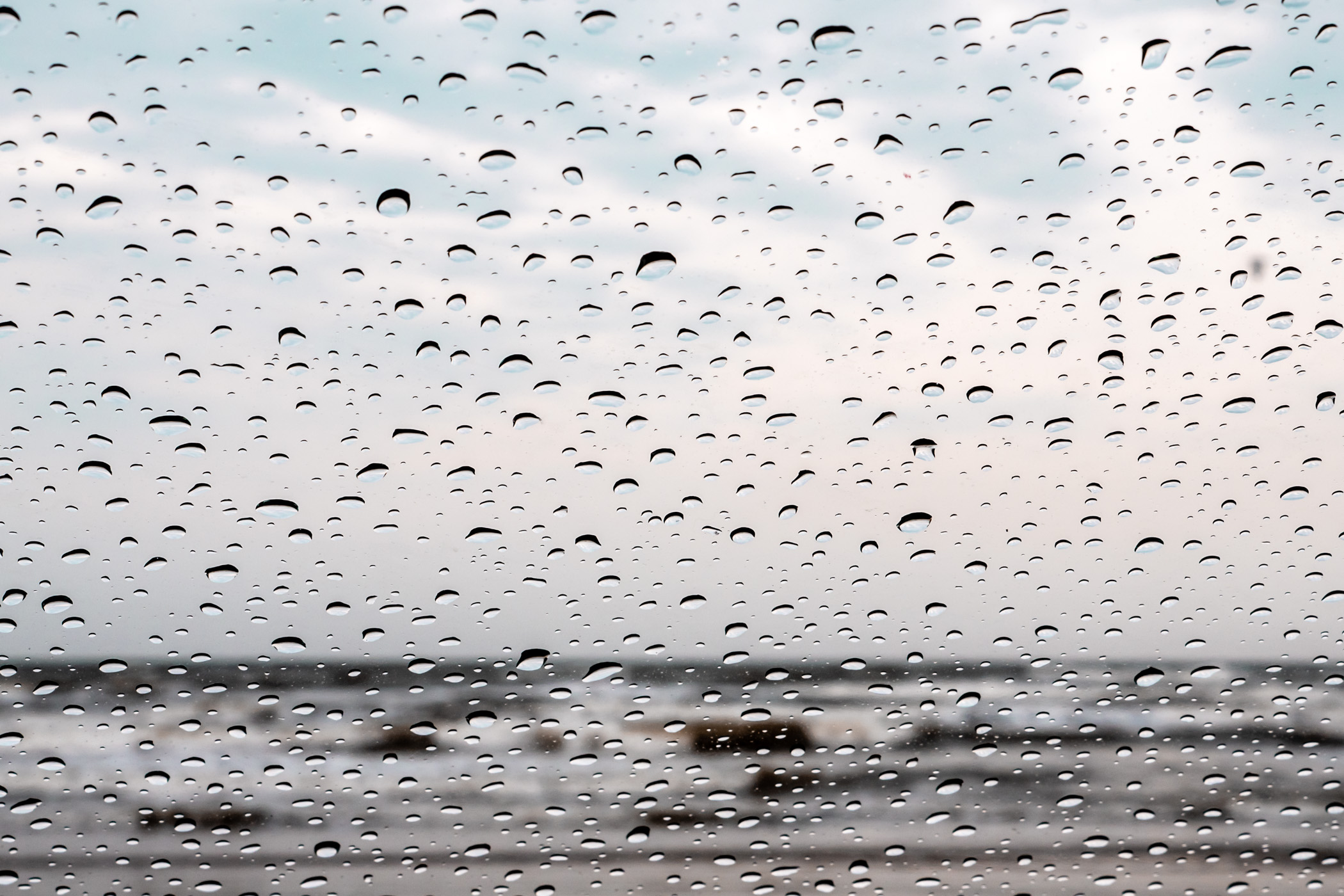 Raindrops on a car's windshield at a Galveston, Texas, beach.