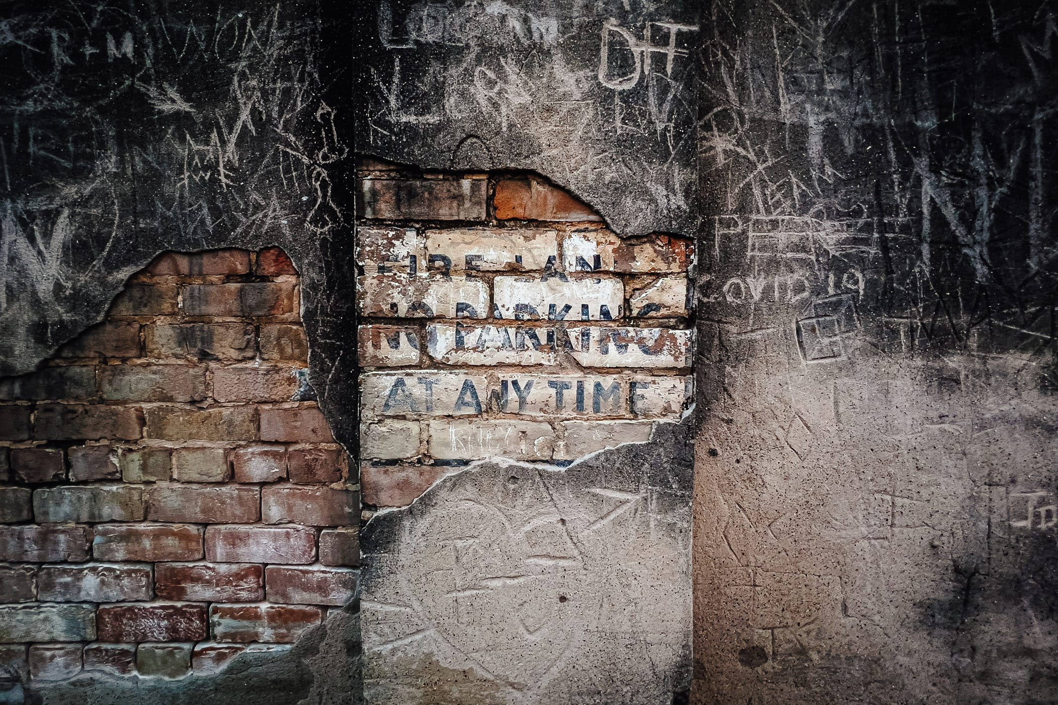 A lost "No Parking" sign painted on a crumbling wall in Downtown McKinney, Texas.