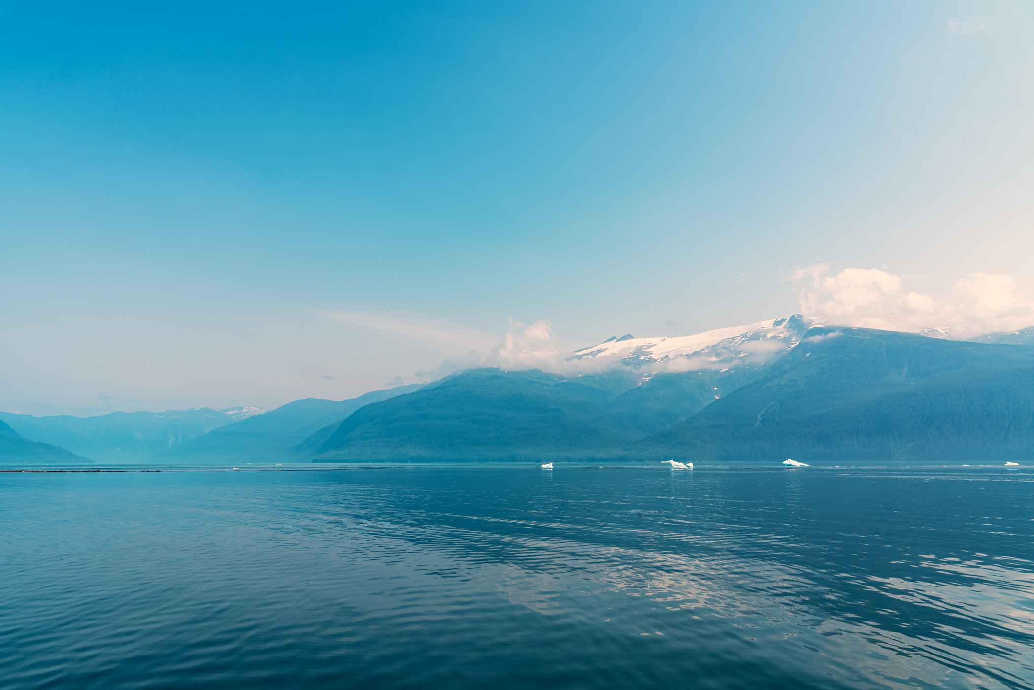 The mountainous shoreline of Alaska's Stephens Passage, near Juneau, on a hazy summer day.