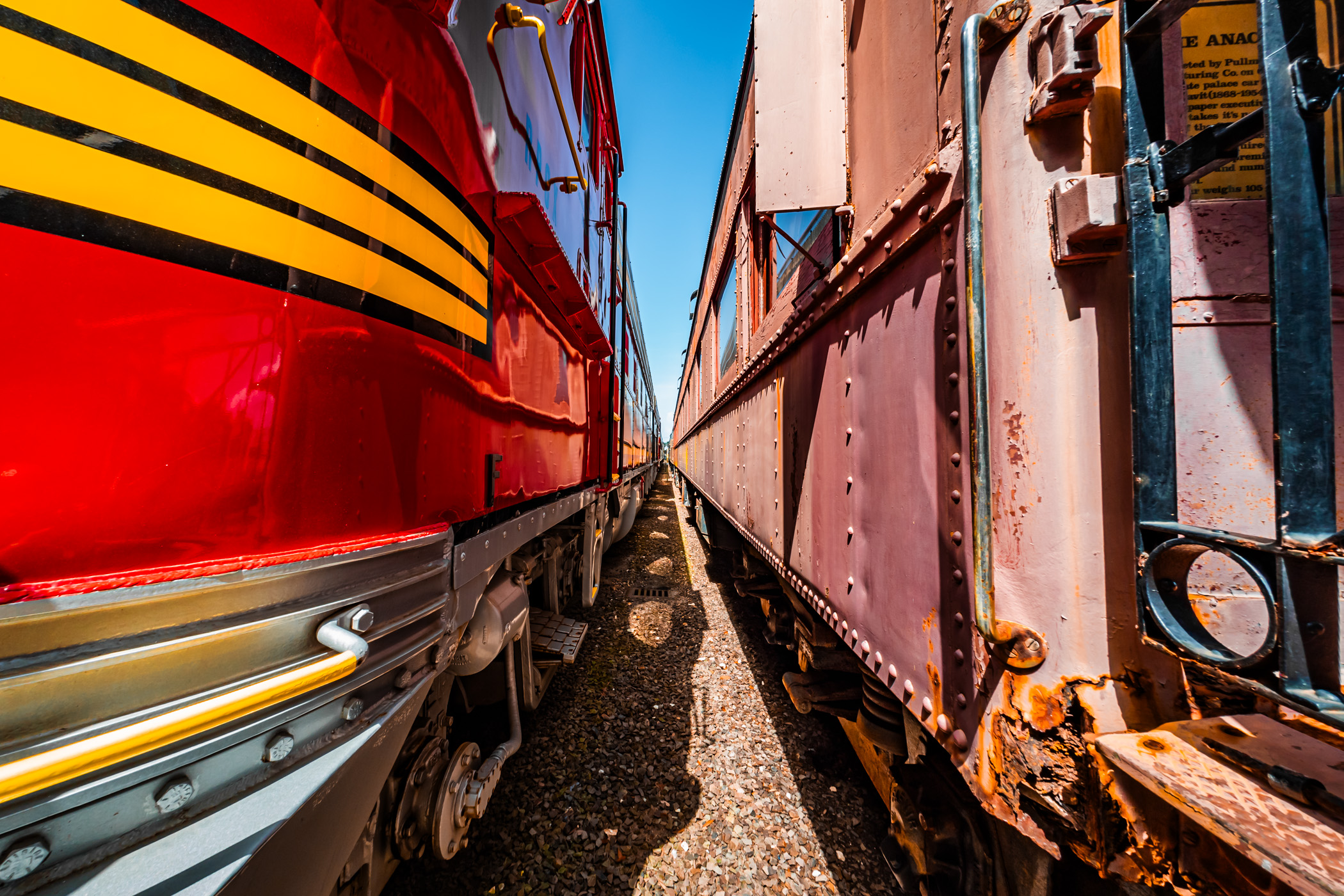 The bright red and yellow "Warbonnet" livery of a Santa Fe Railroad F7 diesel-electric locomotive and adjacent railcars at the Galveston Railroad Museum, Texas.