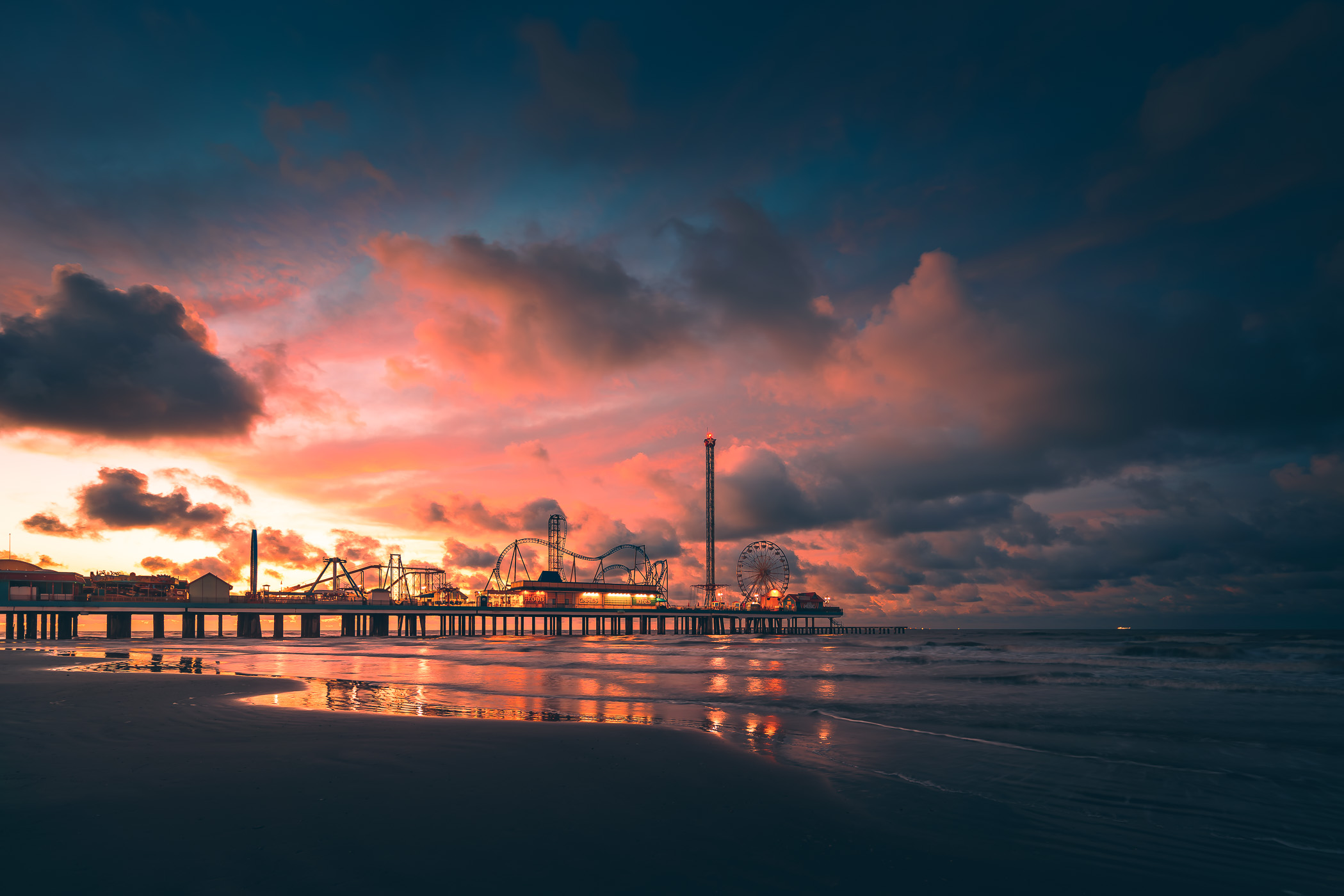 The sun begins to rise on the Galveston Island Historic Pleasure Pier, Texas.