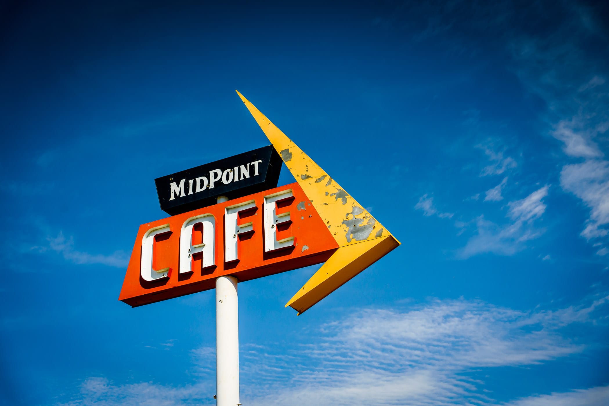 The sign for Adrian, Texas' MidPoint Cafe rises into the Texas Panhandle sky.