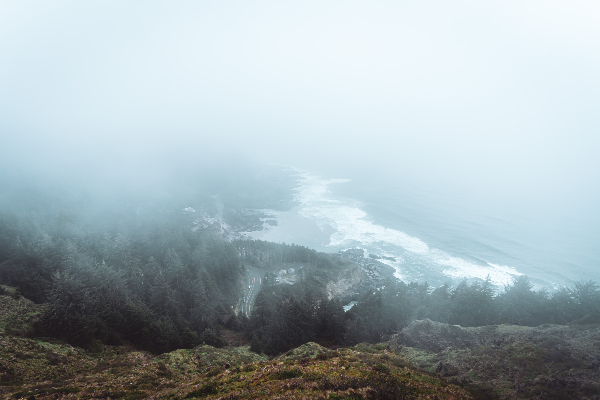 The Oregon Coast Highway (US-101) snakes along the fog-shrouded, rugged Pacific Coast at Cape Perpetua, Oregon.