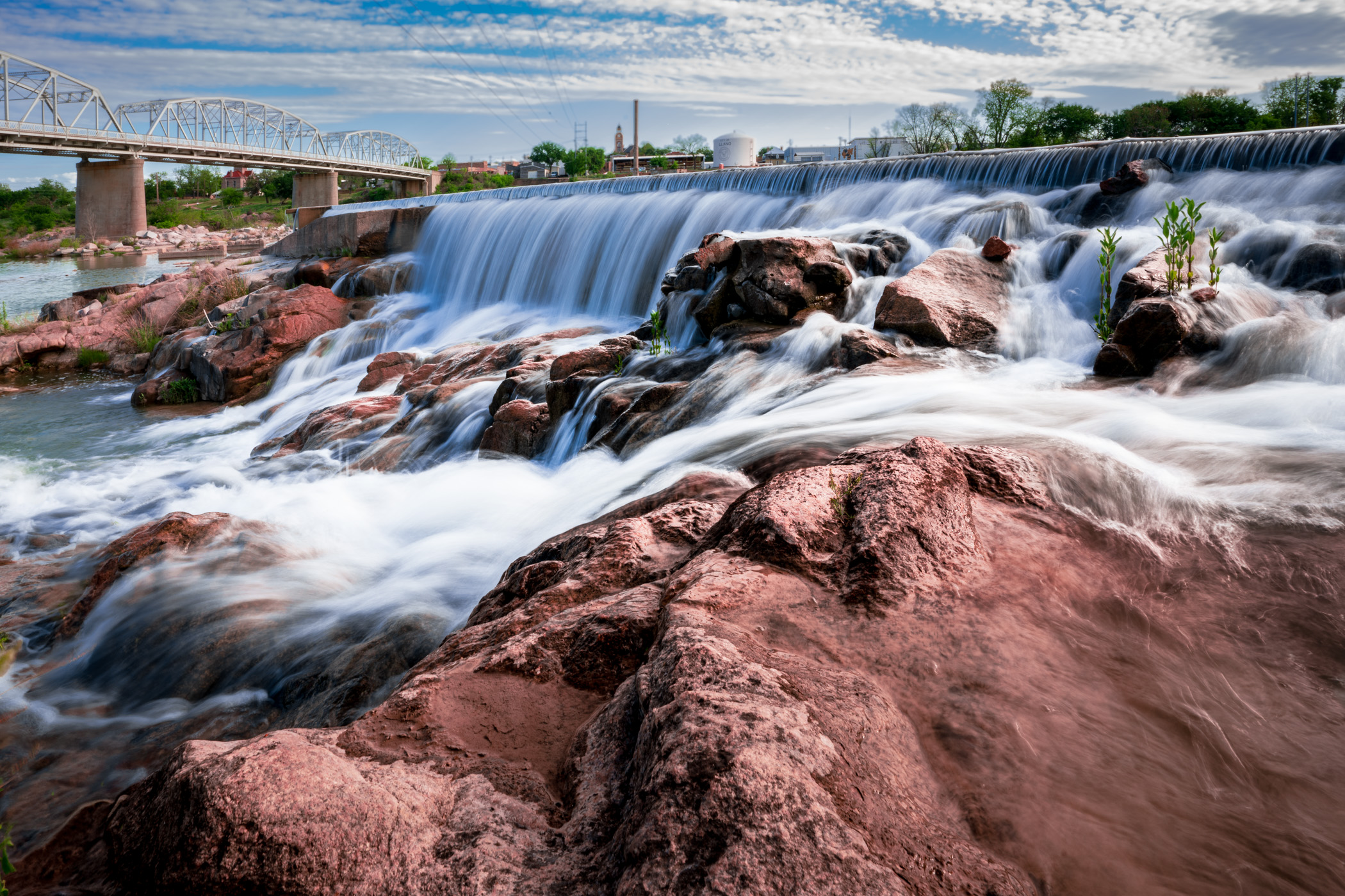 Water crests a dam near the Roy B. Inks Bridge over the Llano River in Llano, Texas.