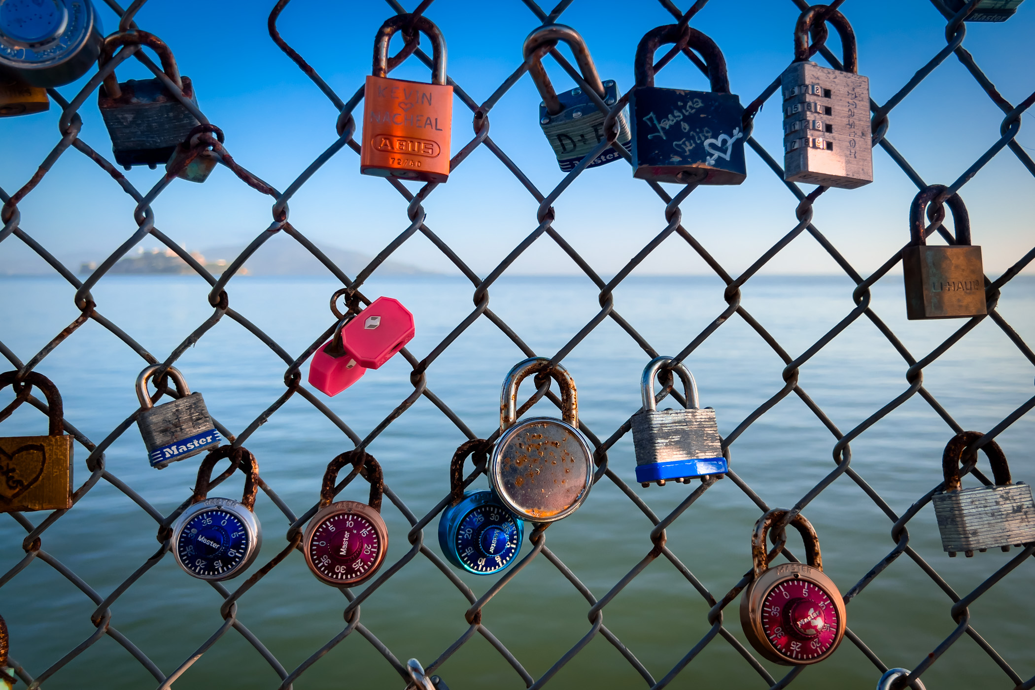 Love locks on a chainlink fence overlooking San Francisco Bay at Fisherman's Wharf, San Francisco.