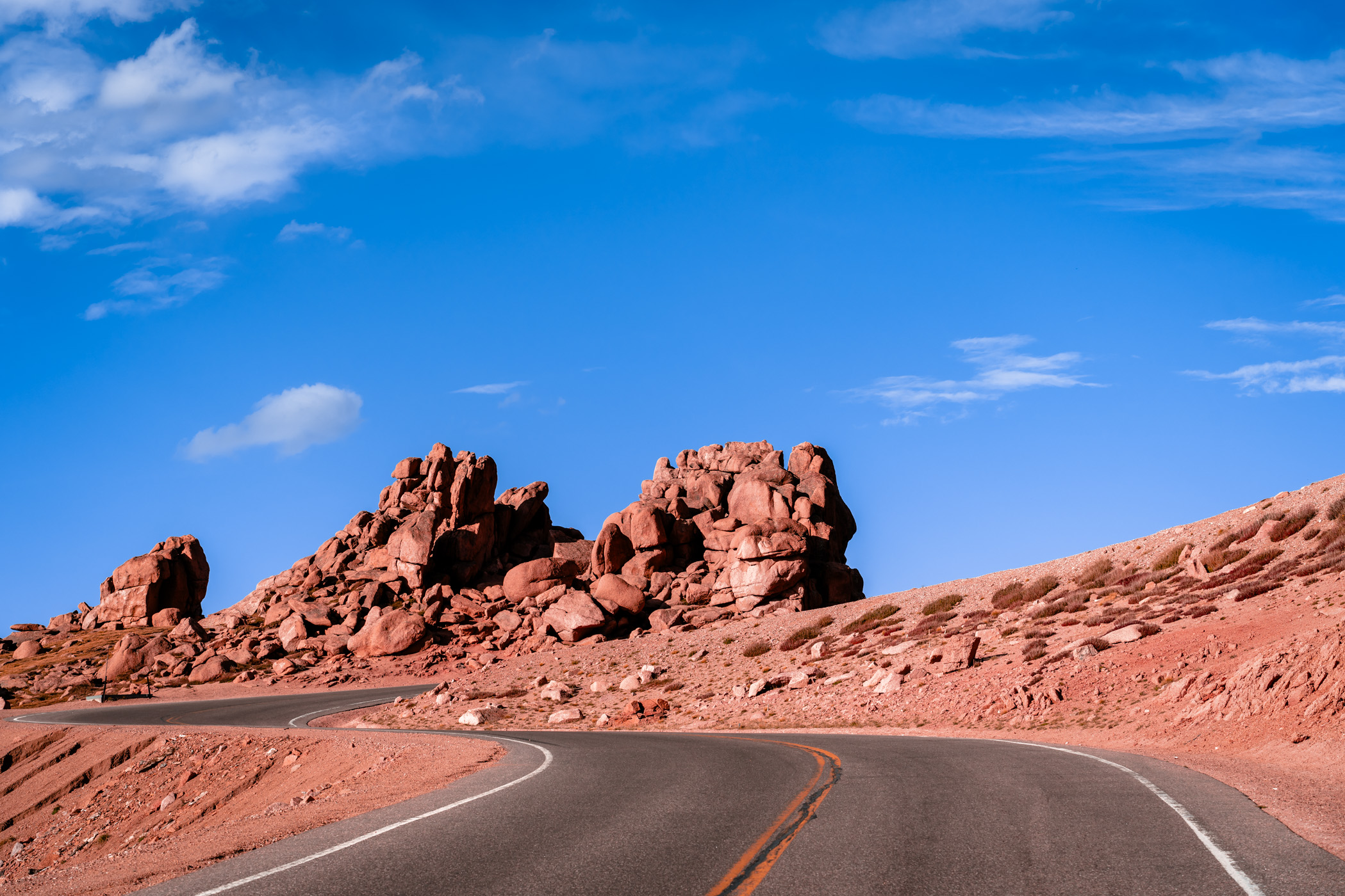 The Pikes Peak Highway curves around the rocky landscape near the summit of its namesake mountain.