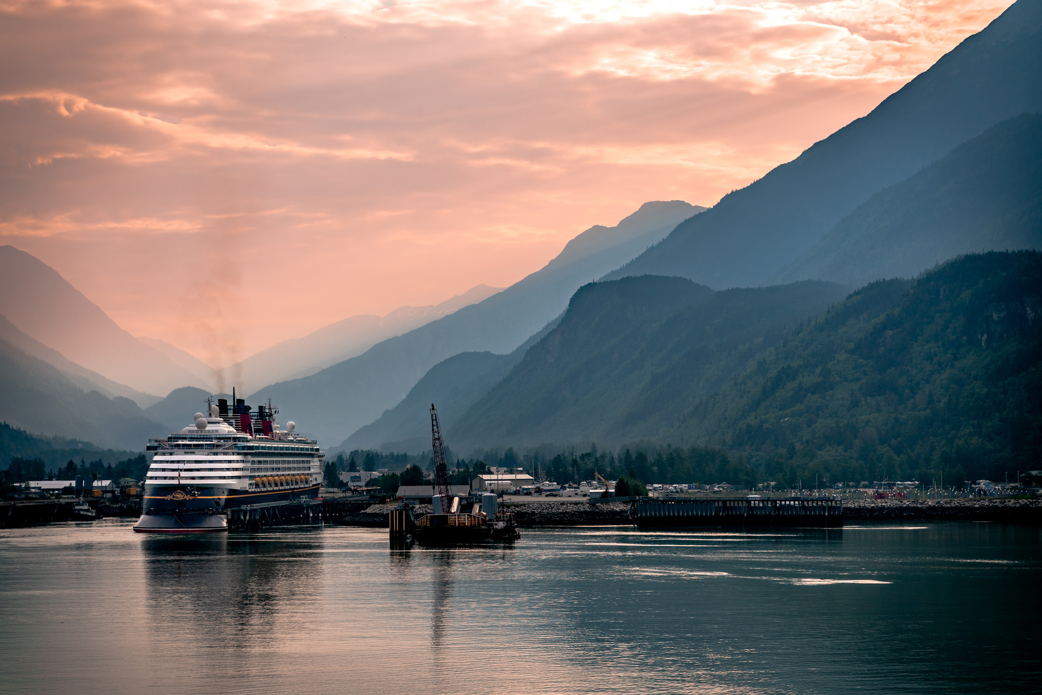 The cruise ship Disney Wonder, docked at Skagway, Alaska, among the summer evening haze.