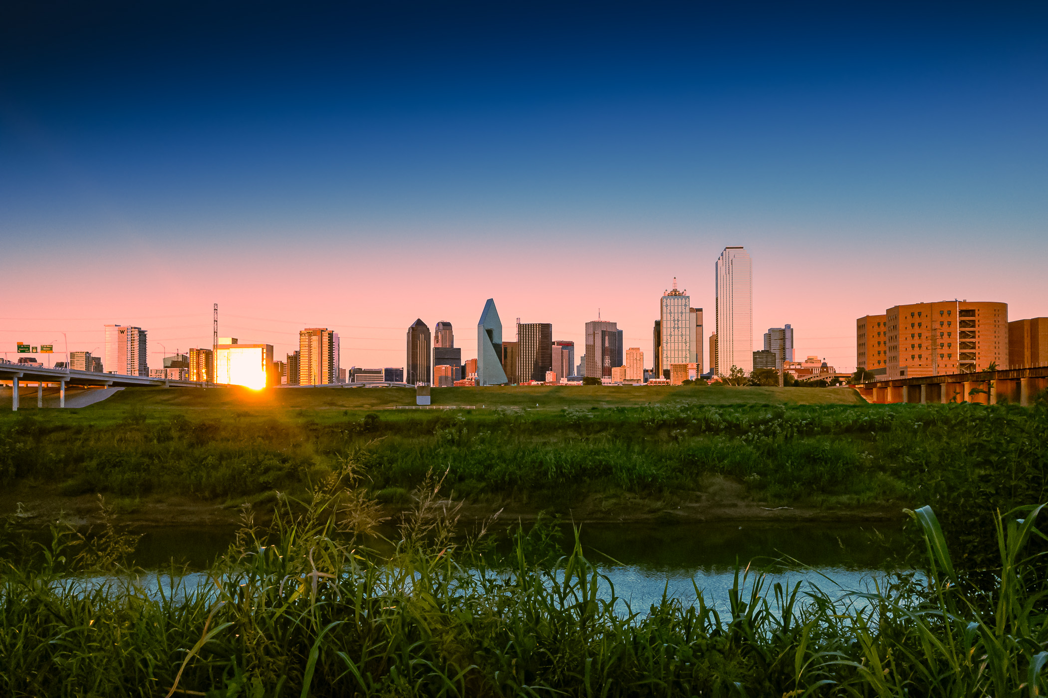 The late-evening sun glints off the buildings of Downtown Dallas.