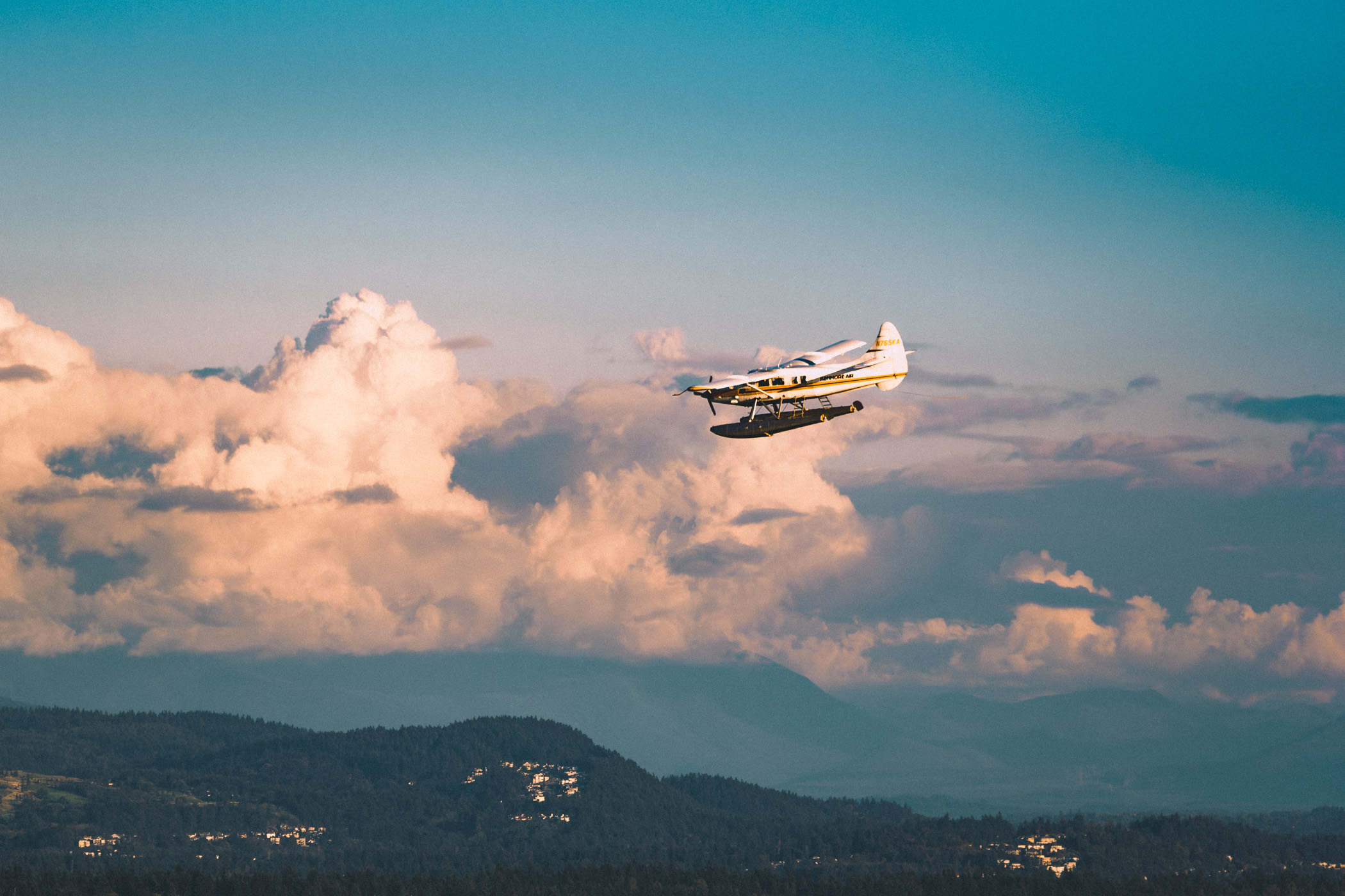 A Kenmore Air floatplane flies over the Seattle-area landscape.