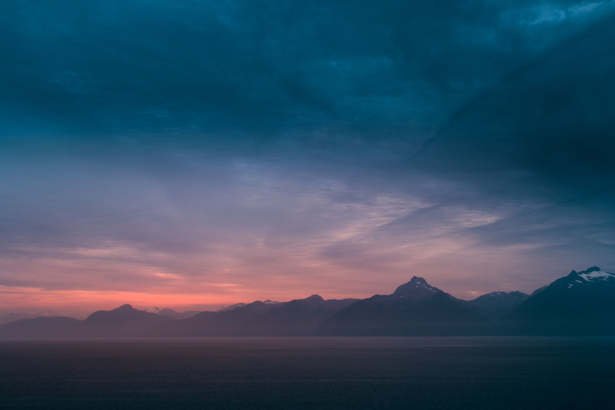 The sun begins to rise behind the mountains of Alaska's Baranof Island.