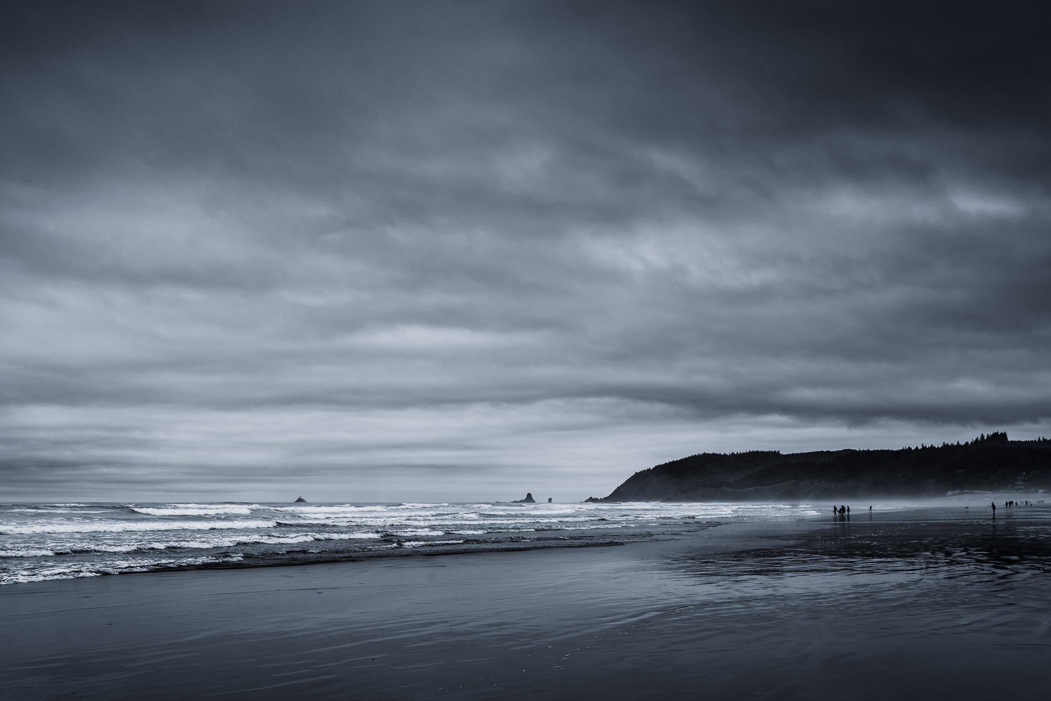 The Pacific Ocean washes ashore at Oregon's Cannon Beach on a cold, overcast day.