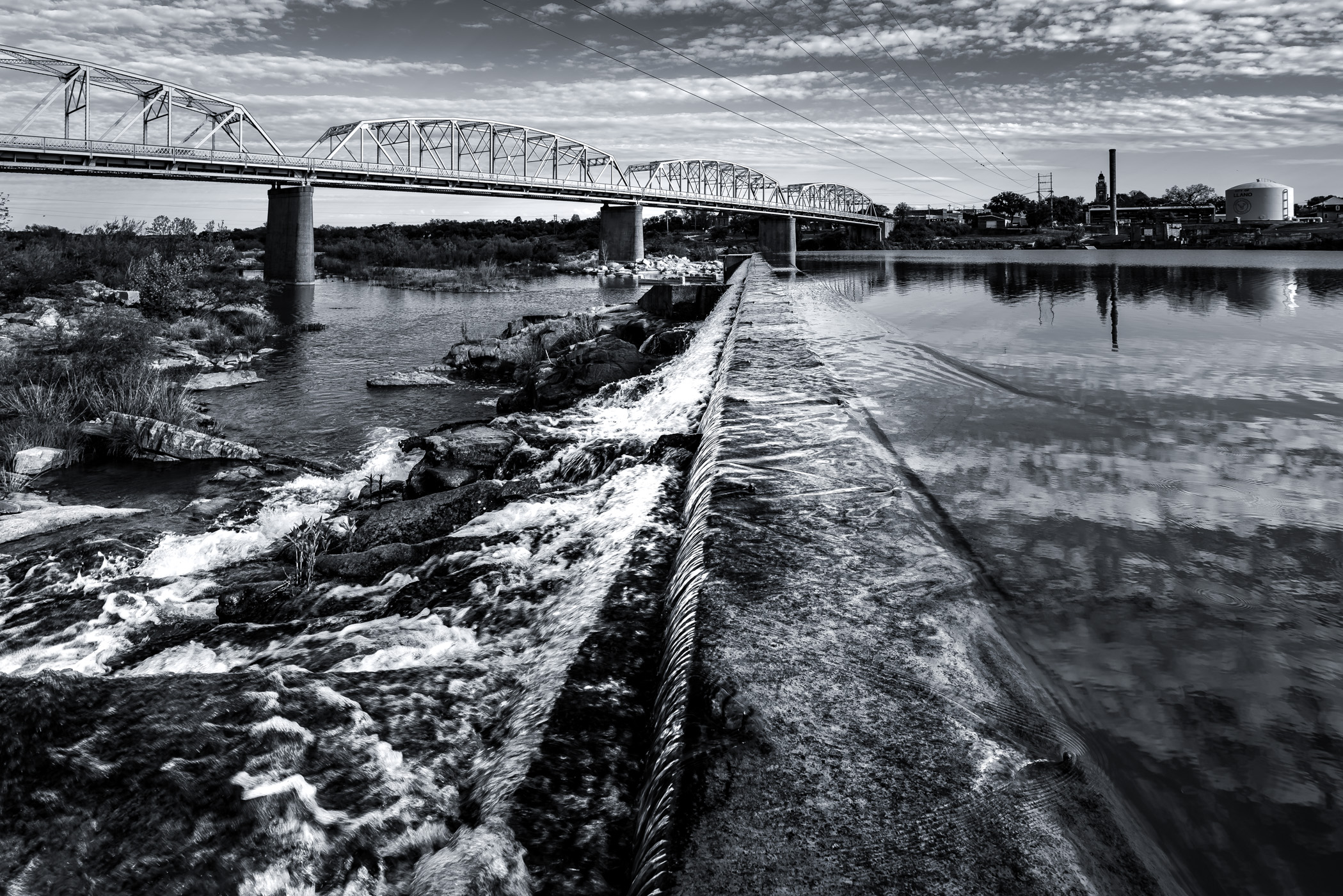 An old concrete dam impounds the Llano River in Llano, Texas.