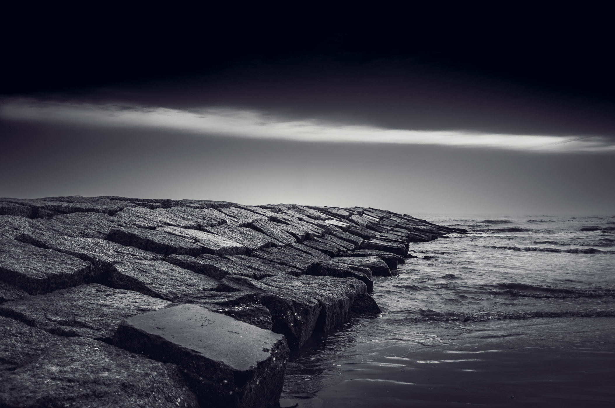 A granite groyne stretches into the Gulf of Mexico from a Galveston, Texas, beach.