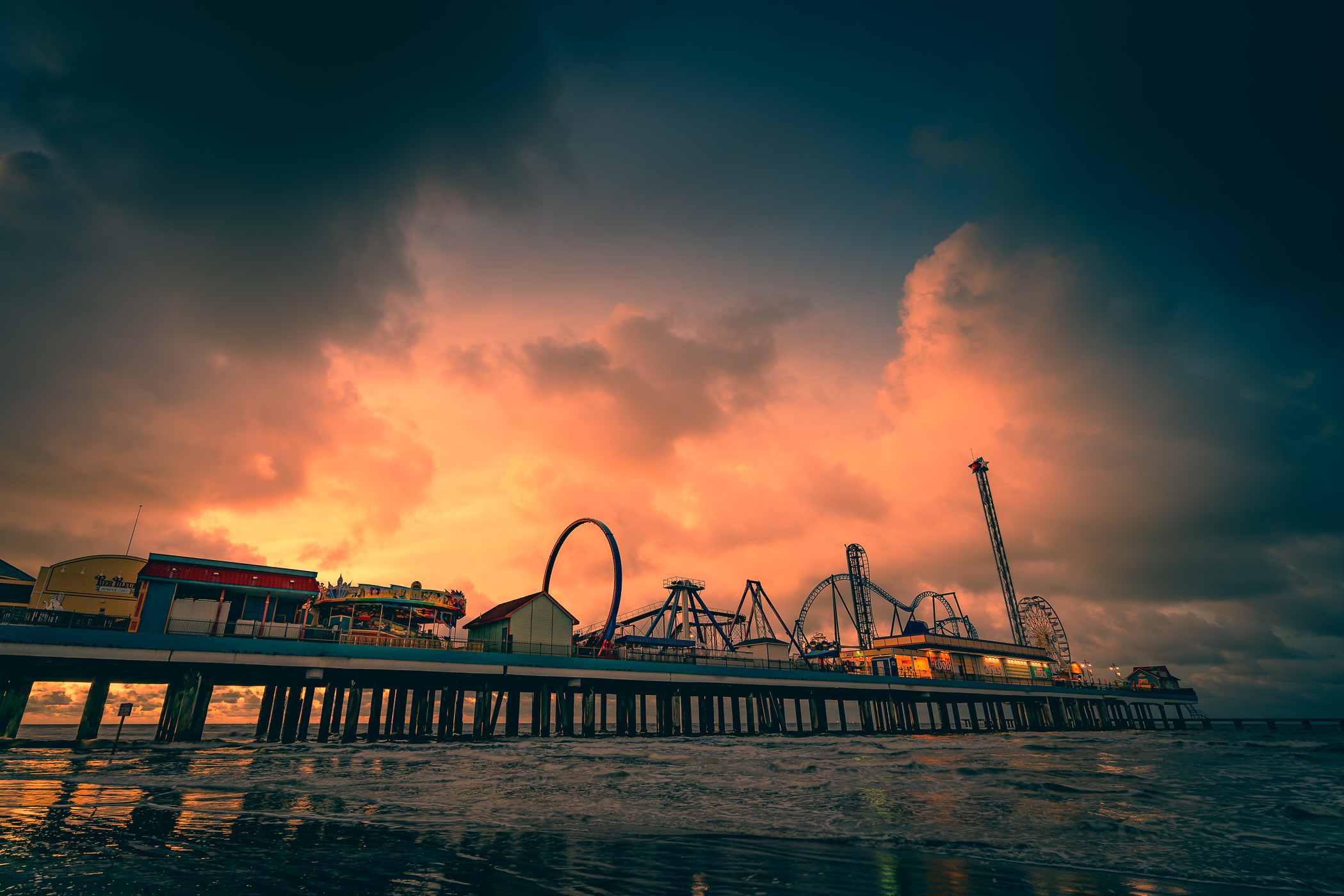 The sun rises over the Gulf of Mexico, silhouetting the Galveston Island Historic Pleasure Pier, Galveston, Texas.