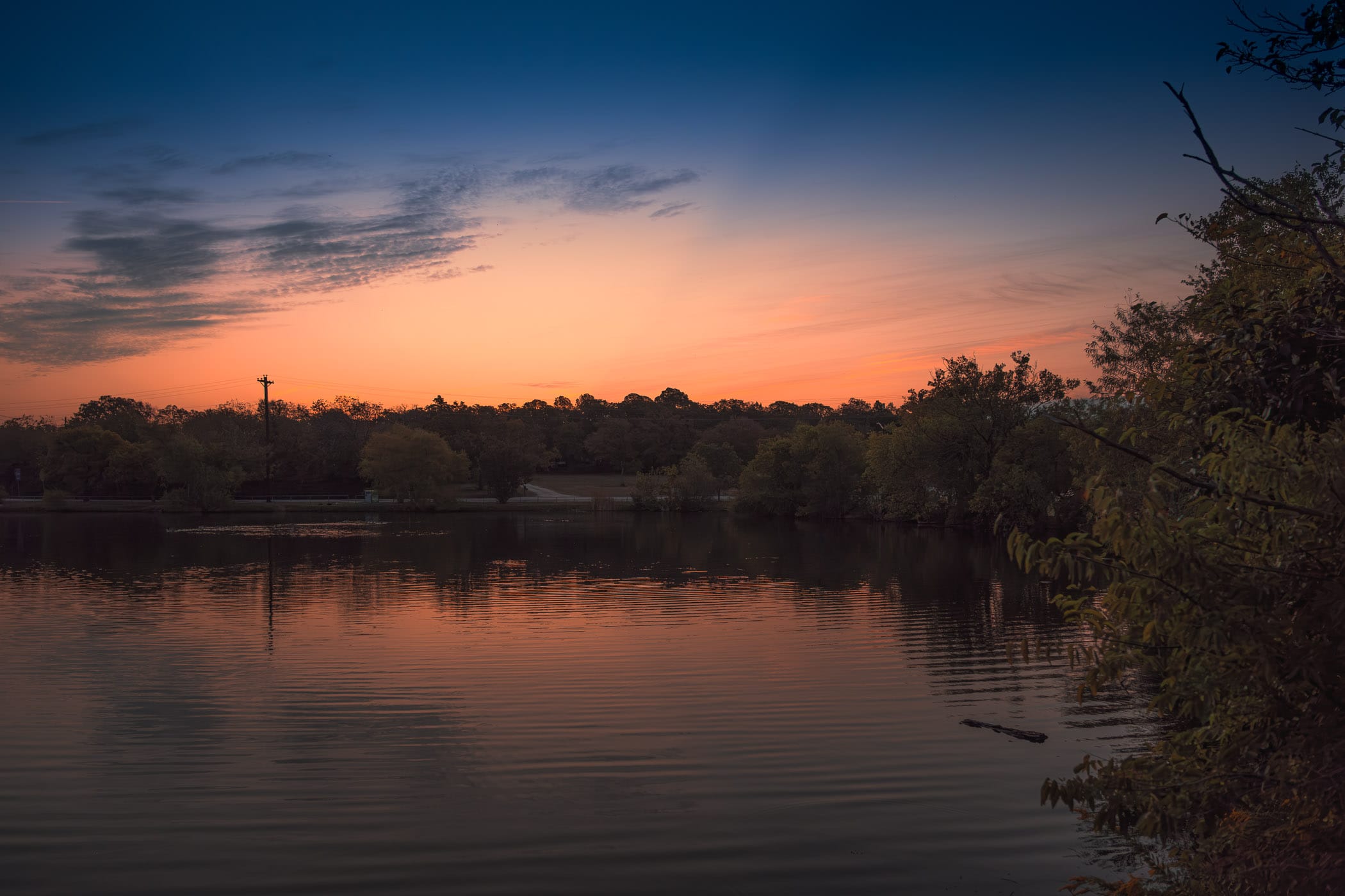 The sun begins to rise on a pond on the campus of the University of North Texas in Denton.