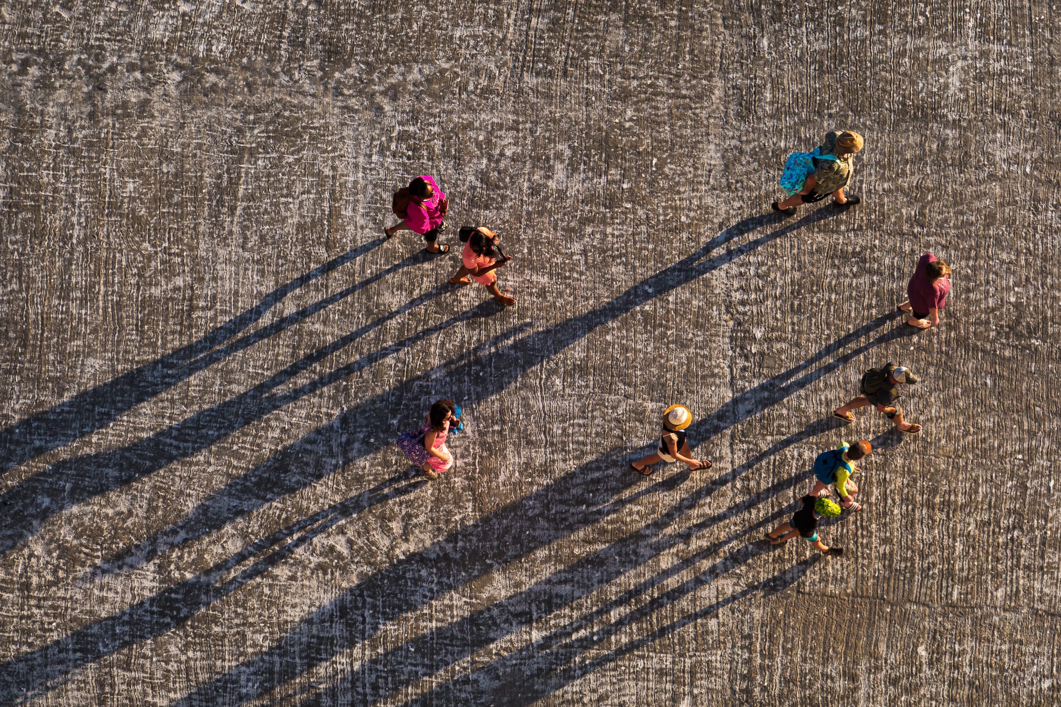 An abstract aerial view of tourists casting long shadows in the evening sun as they return to their cruise ship in Progreso, Mexico.
