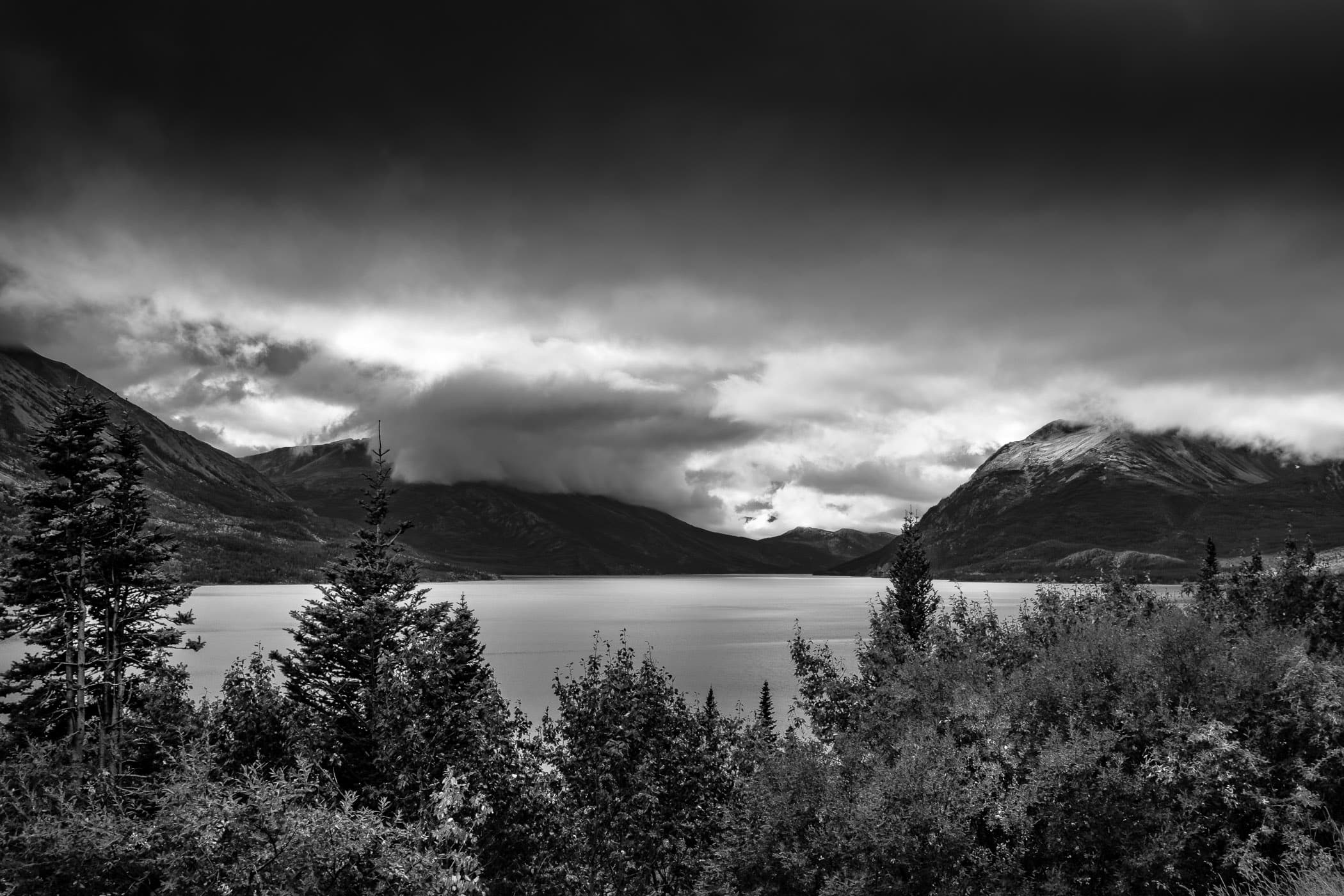 Clouds roll over the mountainous shore of British Columbia's Tutshi Lake.