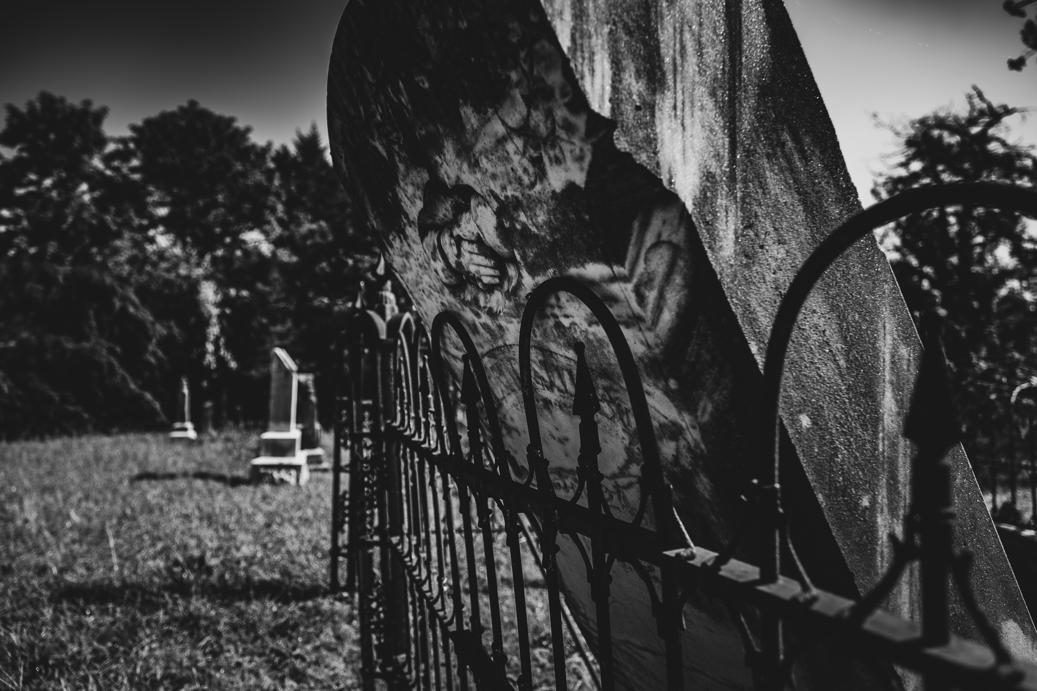 A headstone leans against a fence at Chambersville Cemetery, Texas, as a result of a recent tornado.