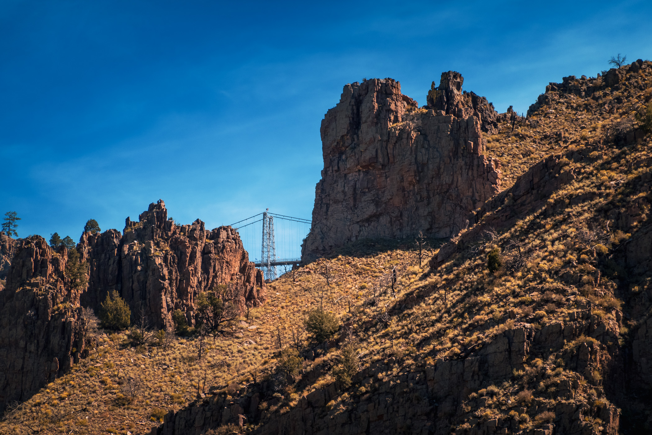 A break in the rugged walls of Royal Gorge offers a glimpse of the Royal Gorge Bridge, Colorado.