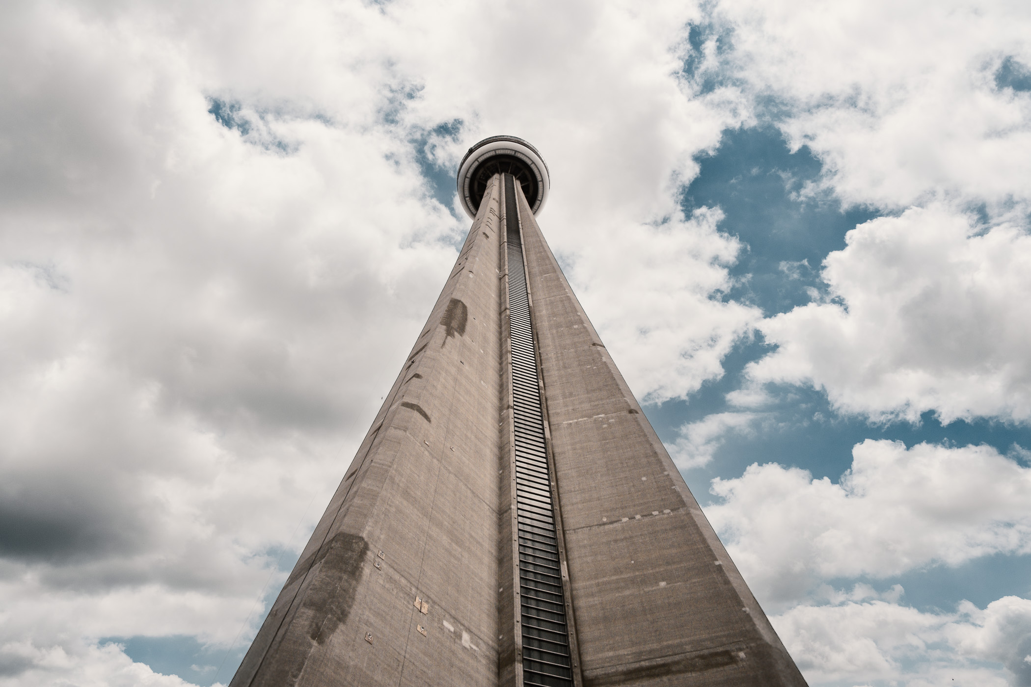 The CN Tower stretches into the cloudy sky over Toronto, Ontario.