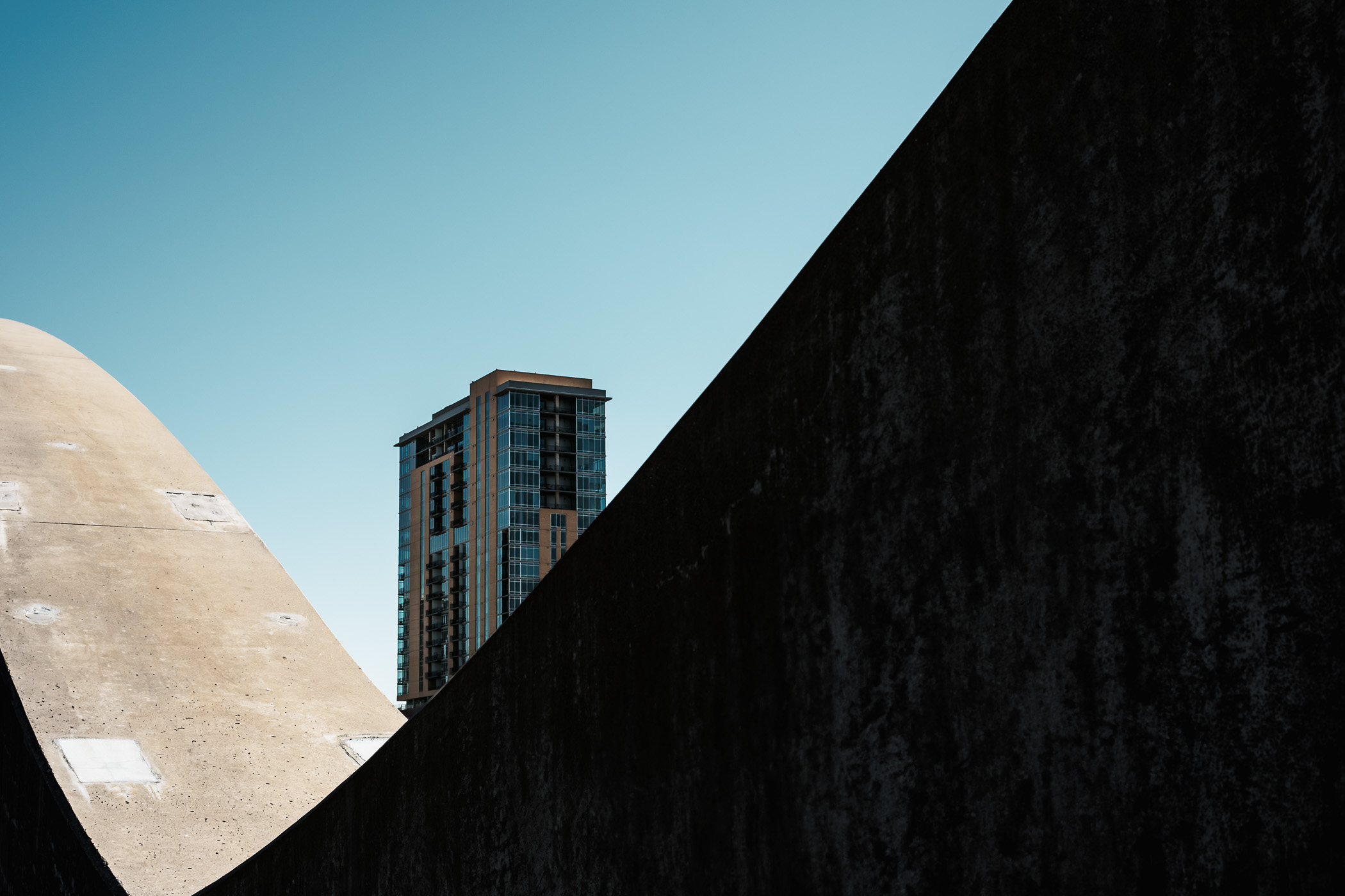 The Trinity Terrace tower peeks over the concrete curves of Fort Worth, Texas' West 7th Street Bridge.