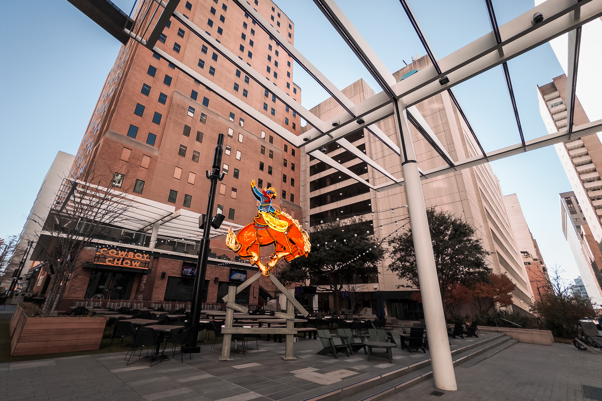 A neon cowboy rides a bucking bronco at Cowboy Chow in Downtown Dallas' AT&T Discovery District.