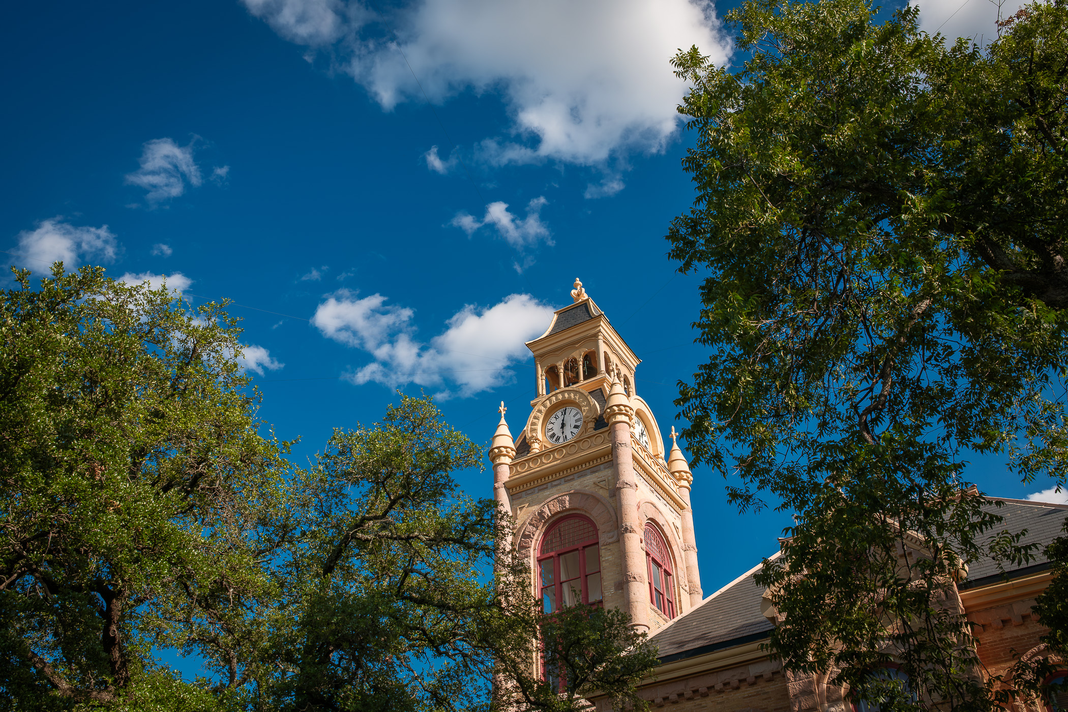 The clock tower of the Llano County Courthouse rises into the blue Texas Hill Country sky in Downtown Llano. The clock tower of the Llano County Courthouse rises into the blue Texas Hill Country sky in Downtown Llano.
